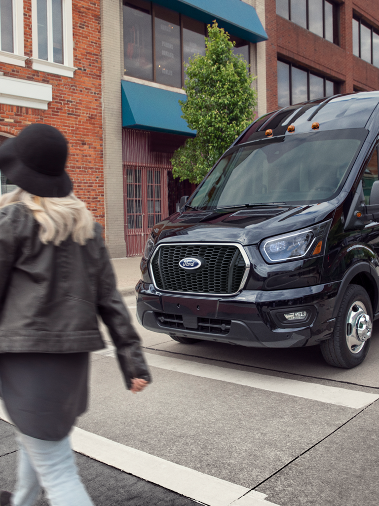 Black 2026 Ford Transit® van being driven on a city street