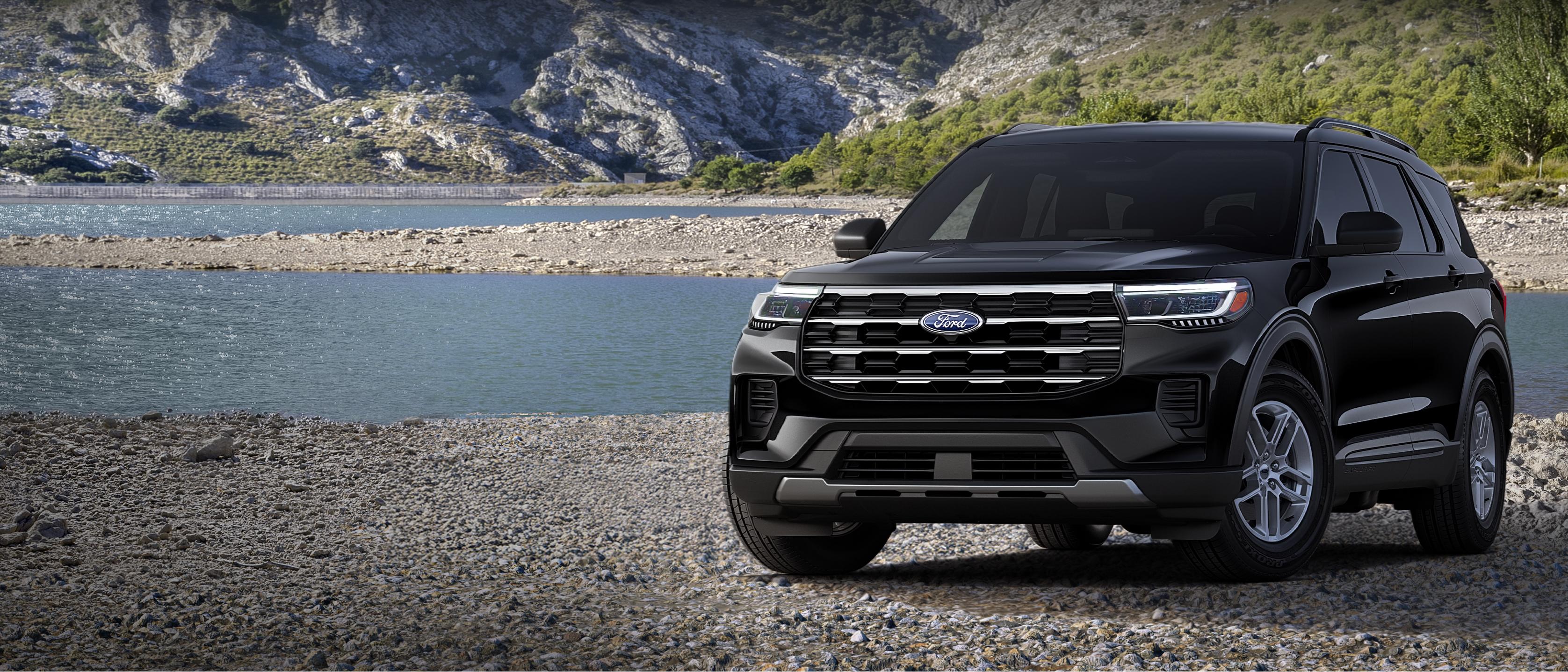 A 2026 Ford Explorer® Active model parked on a rocky expanse near a mountain lake