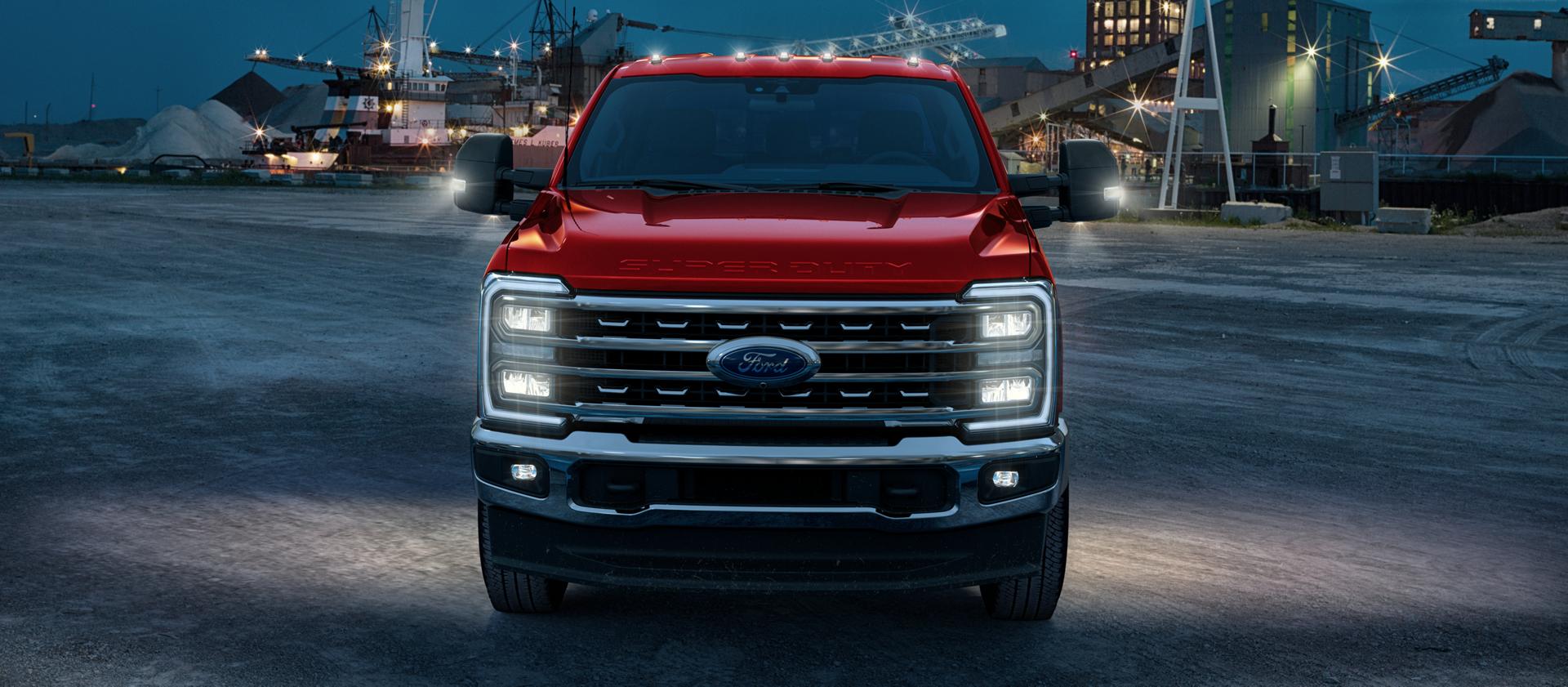 2026 Ford Super Duty® F-450® Lariat® truck with its lights on parked on a construction site at dusk