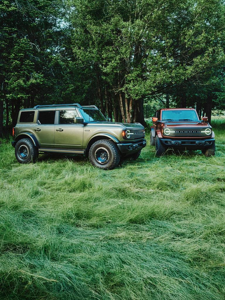 Two 2027 Ford Bronco® Filson SUVs parked in a grassy clearing
