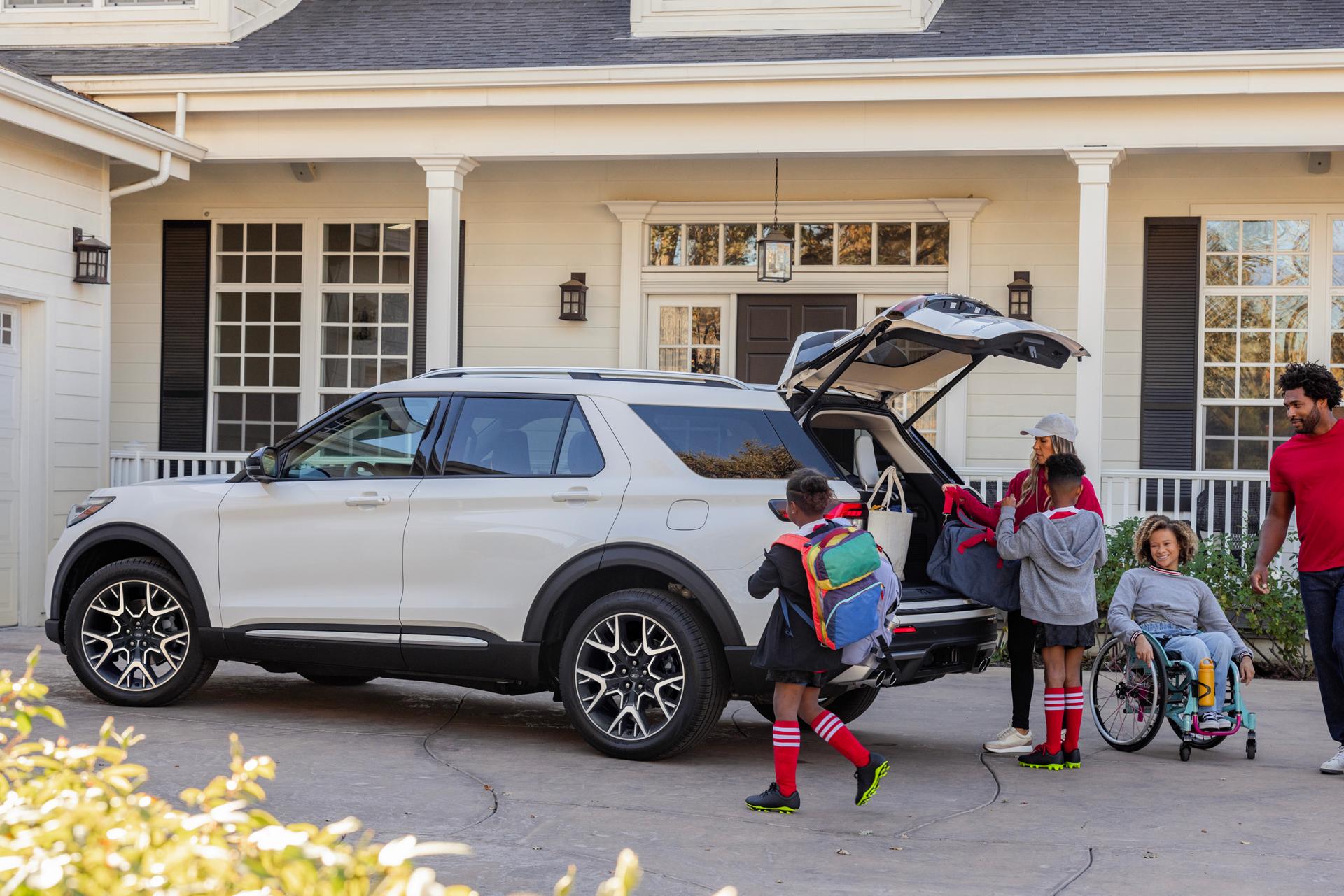 A family loads bags into the back of a Ford SUV.