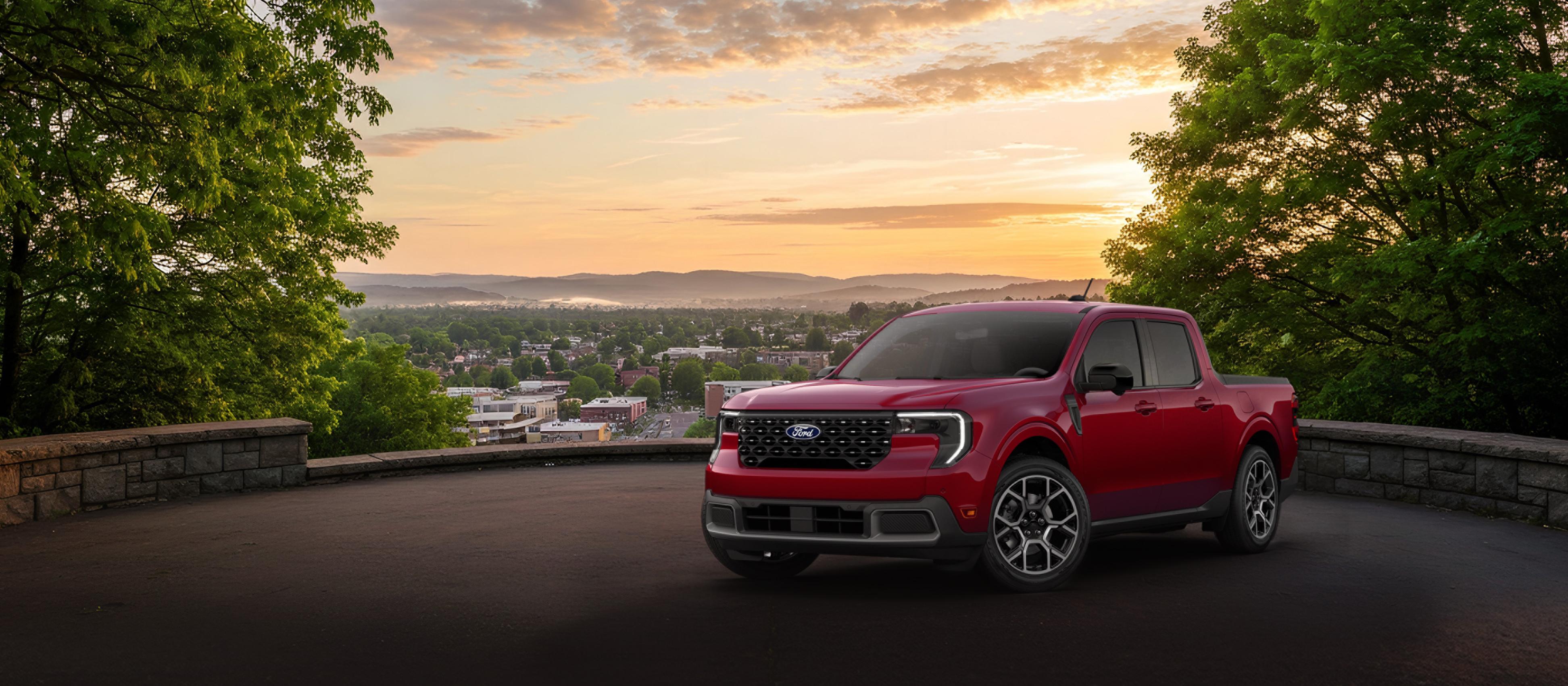 2026 Ford Maverick® Lariat® model in Ruby Red Metallic Tinted Clear-coat (extra-colour cost) parked overlooking a city