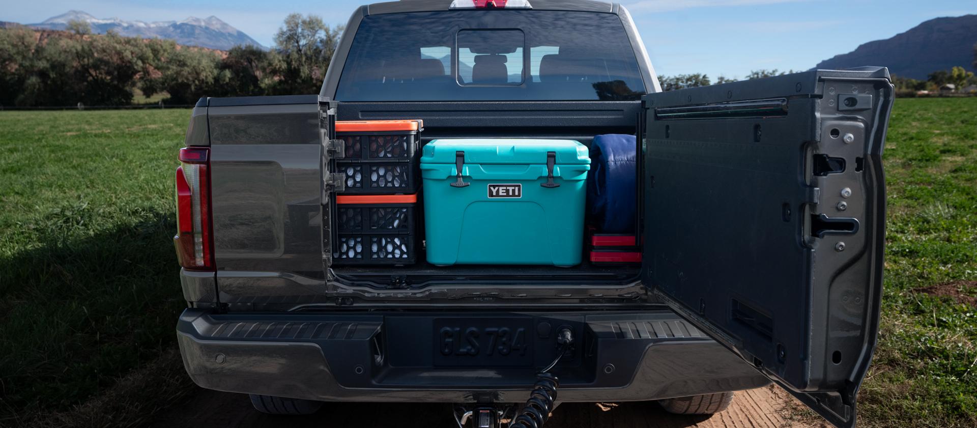Rear view of a 2025 Ford F-150® pickup with the Pro Access Tailgate open showing items in the truck bed