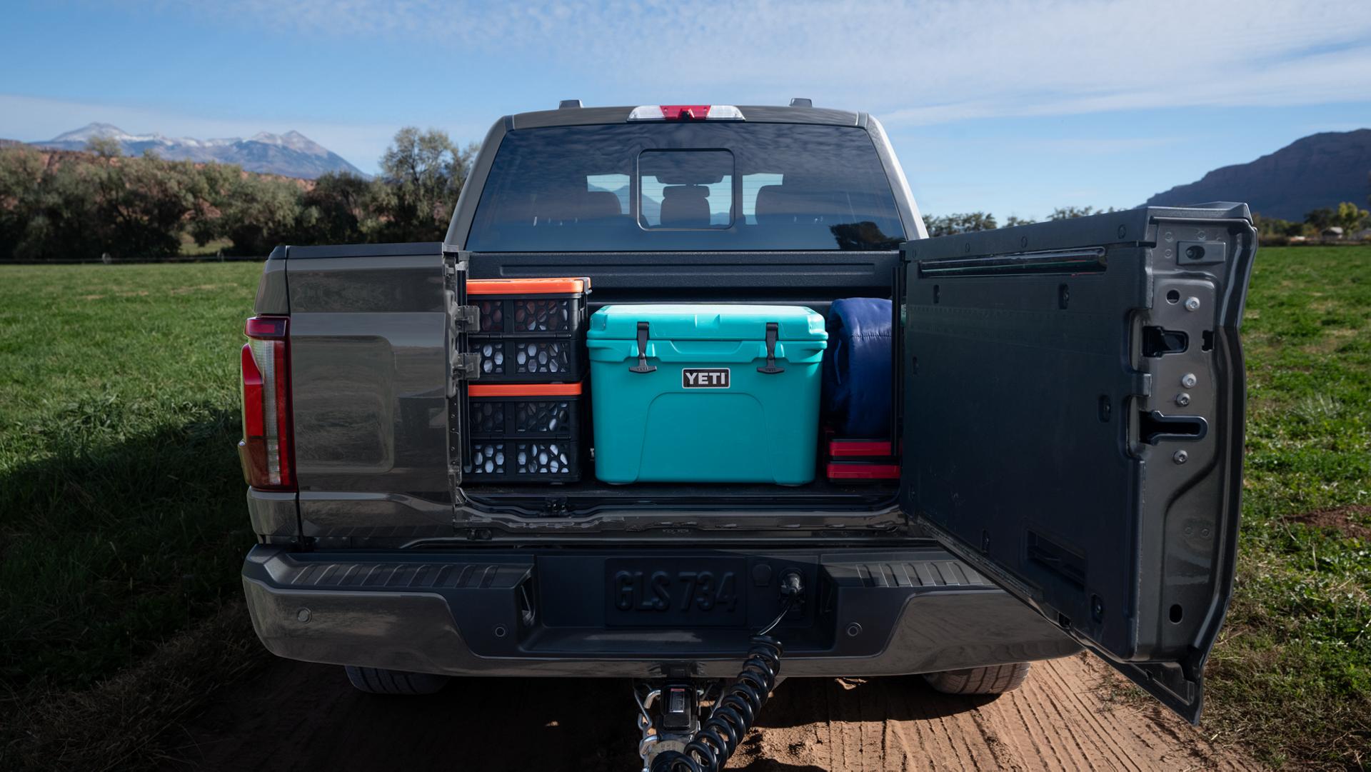 Rear view of a 2025 Ford F-150® pickup with the Pro Access Tailgate open showing items in the truck bed