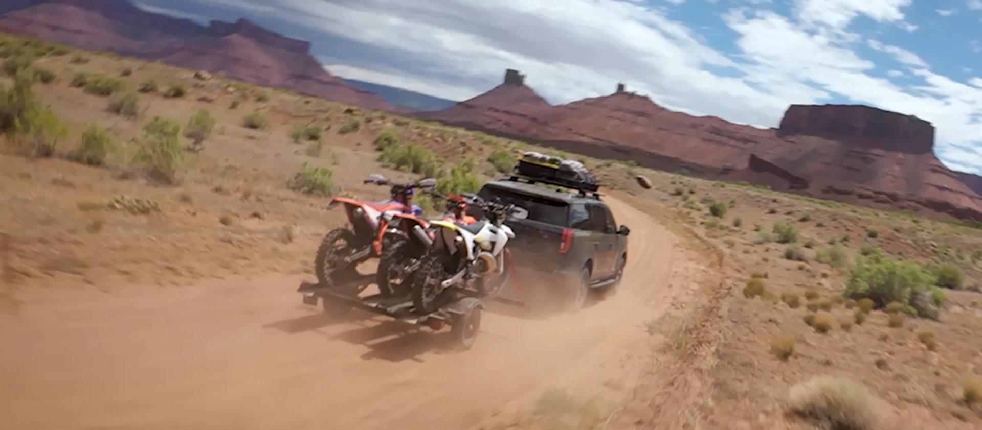 A 2026 Ford Expedition® Tremor® model being driven in the desert while towing a trailer