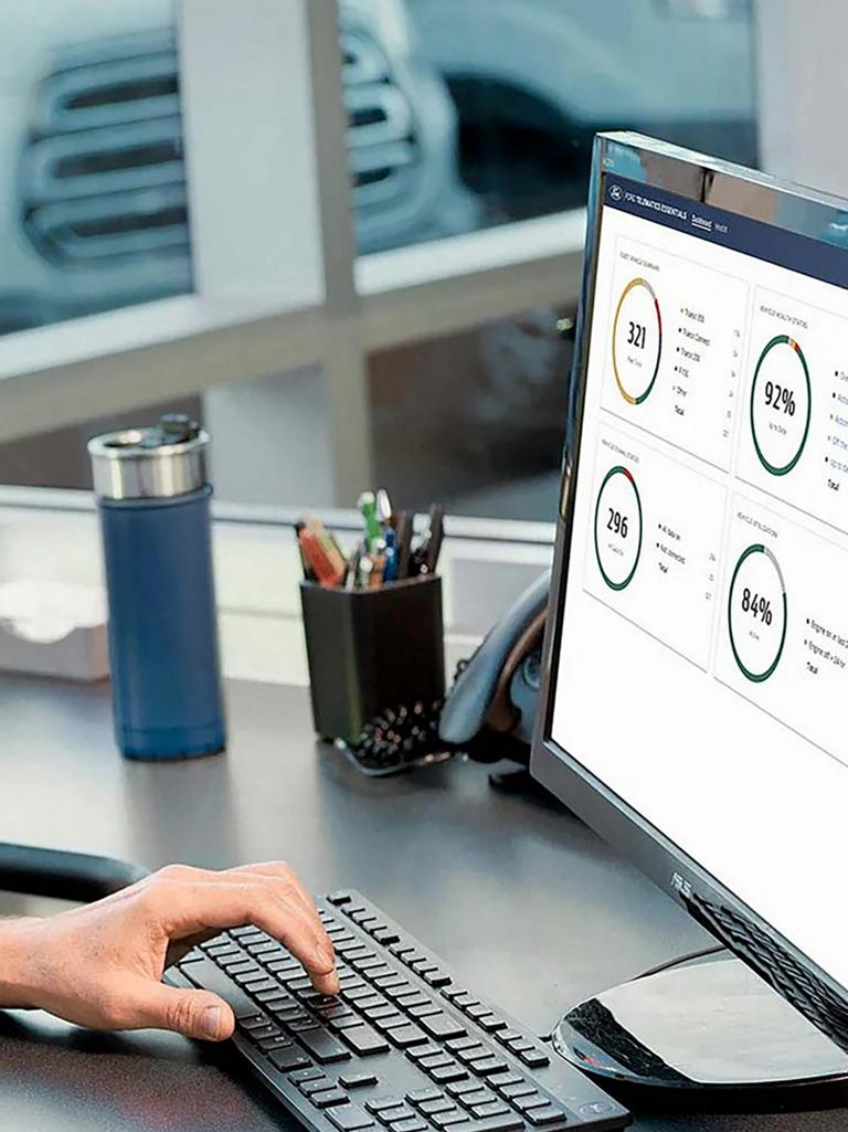 Man at office desk looking at computer screen with percentage pie charts