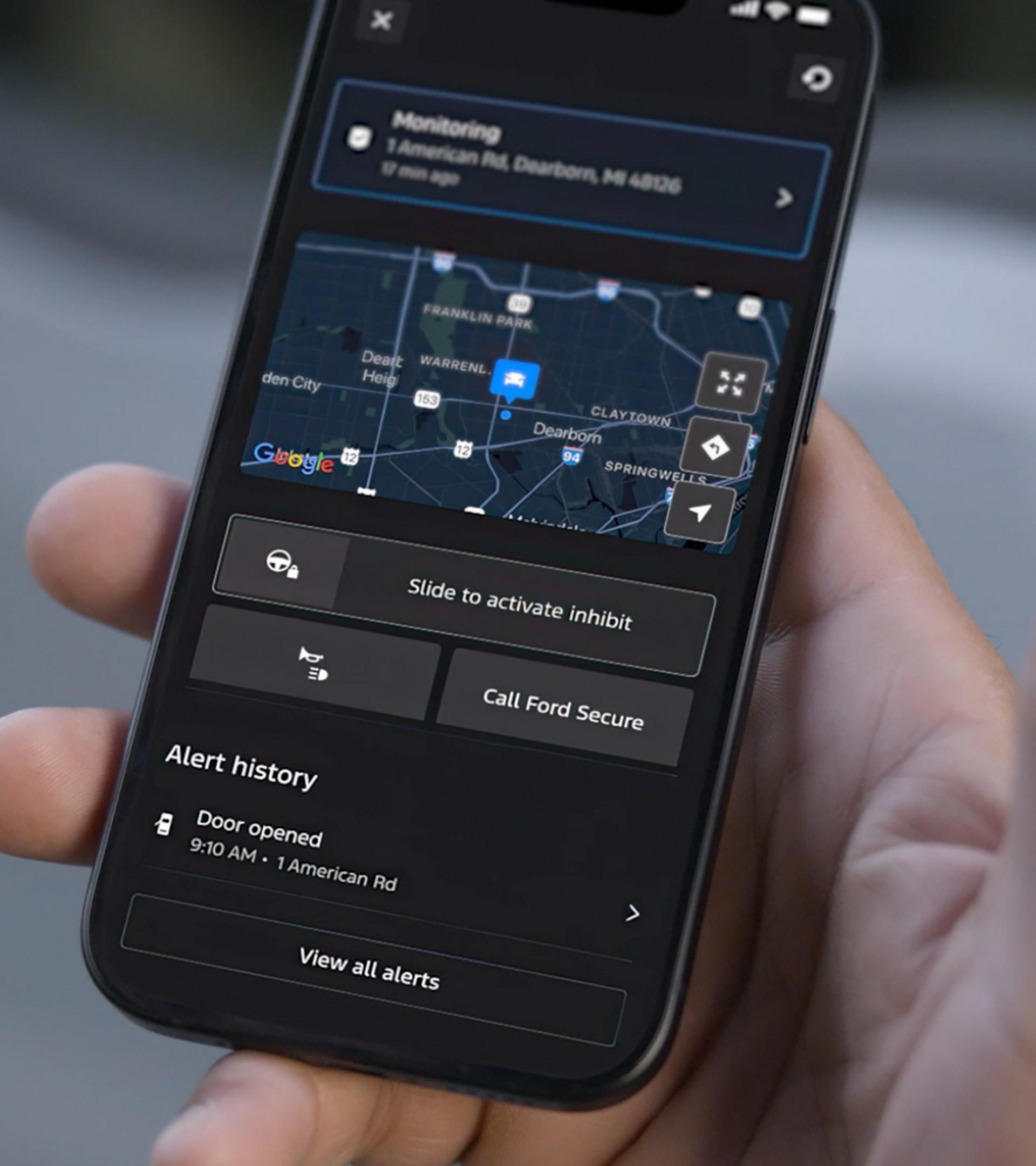 Close-up of a person holding a phone, displaying the Ford Security map features