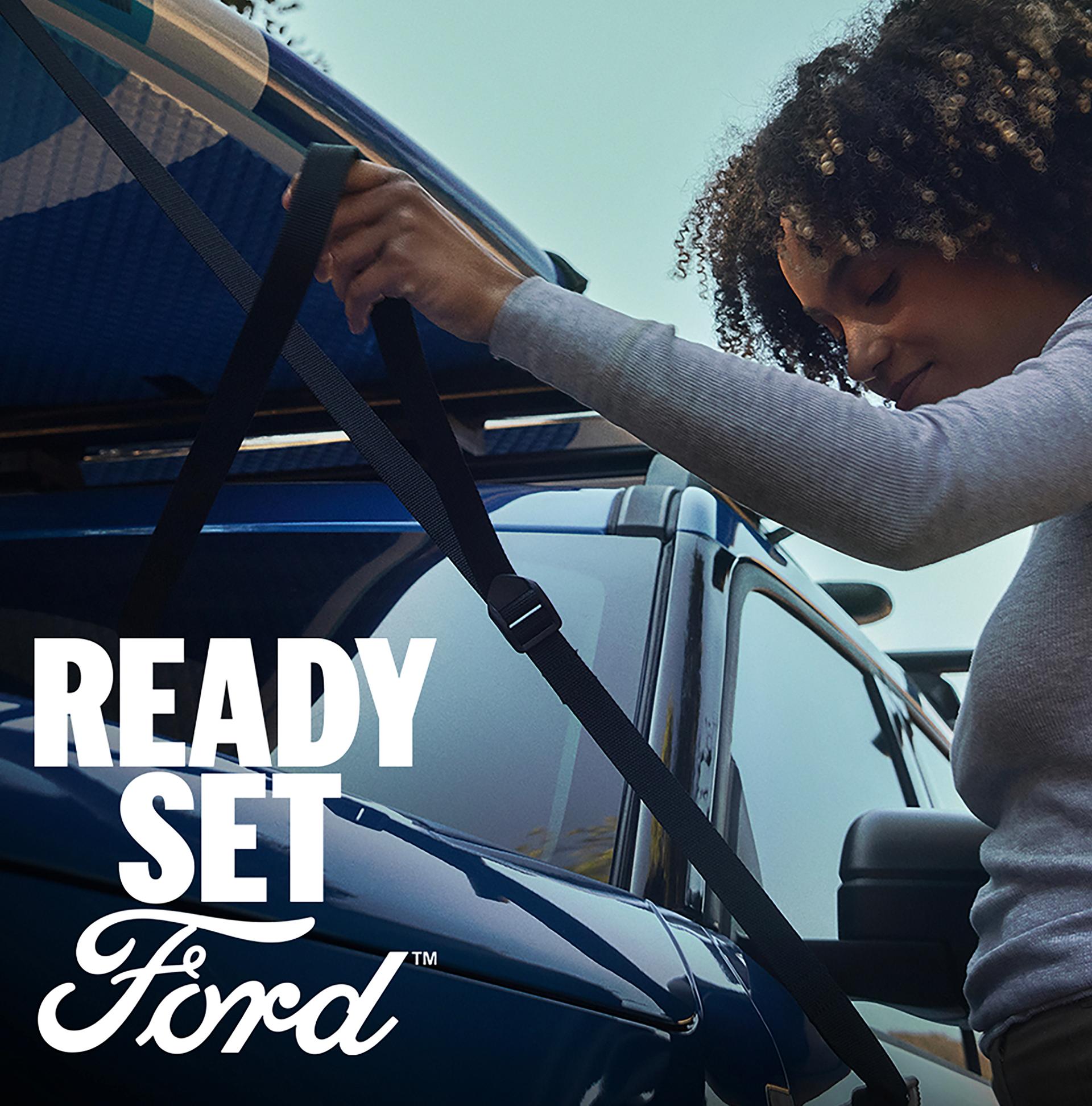A person securing a paddle board  to the roof of a 2026 Ford Bronco Sport® SUV