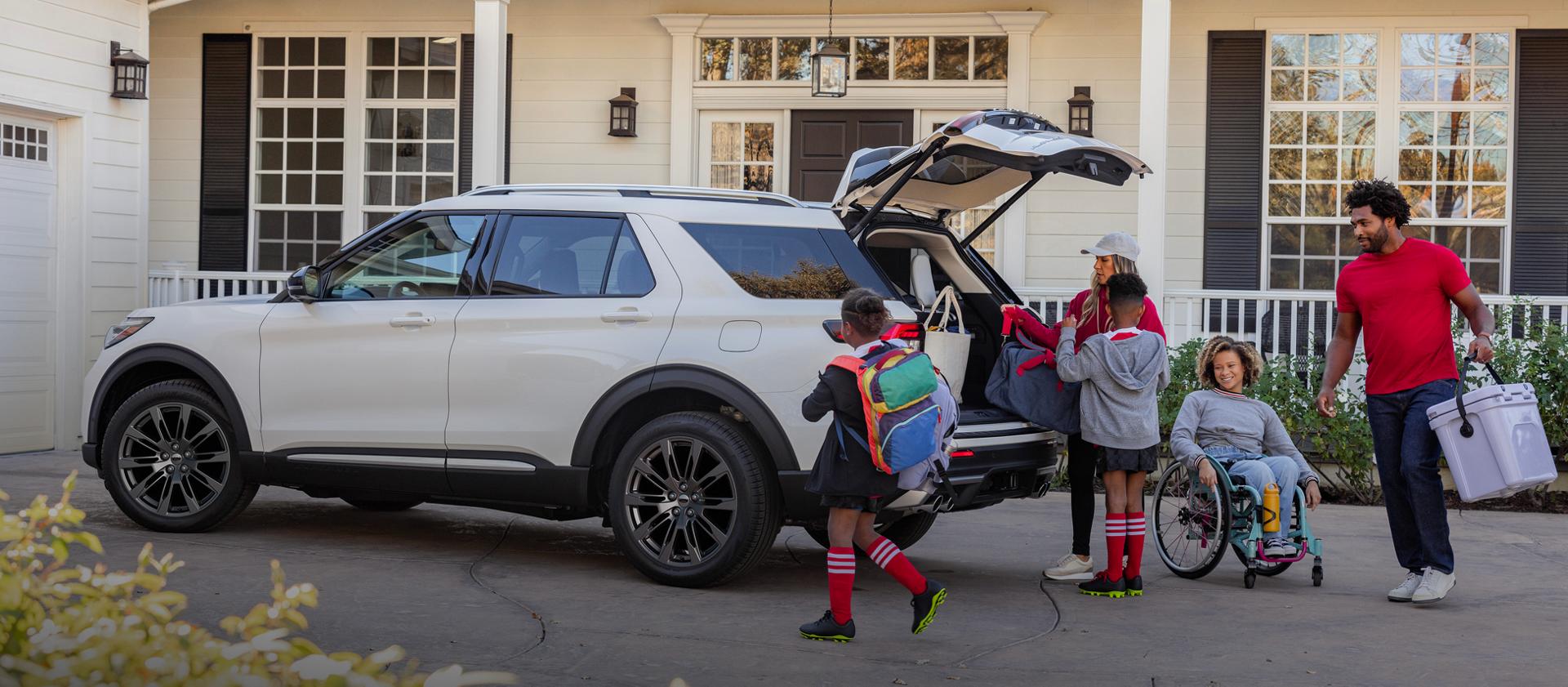 A family packing luggage into the rear of a 2026 Ford Explorer® SUV