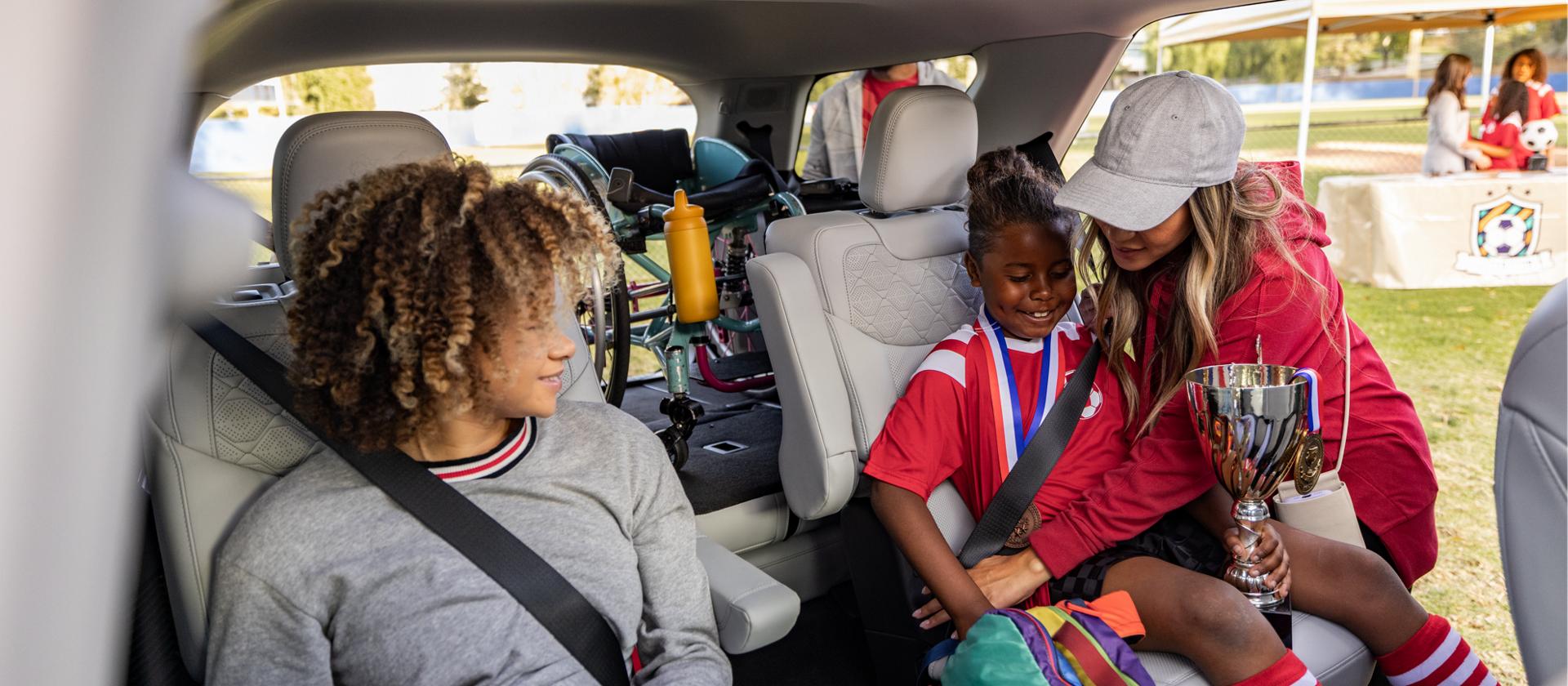 A woman helping children into the rear seats of a 2026 Ford Explorer® SUV