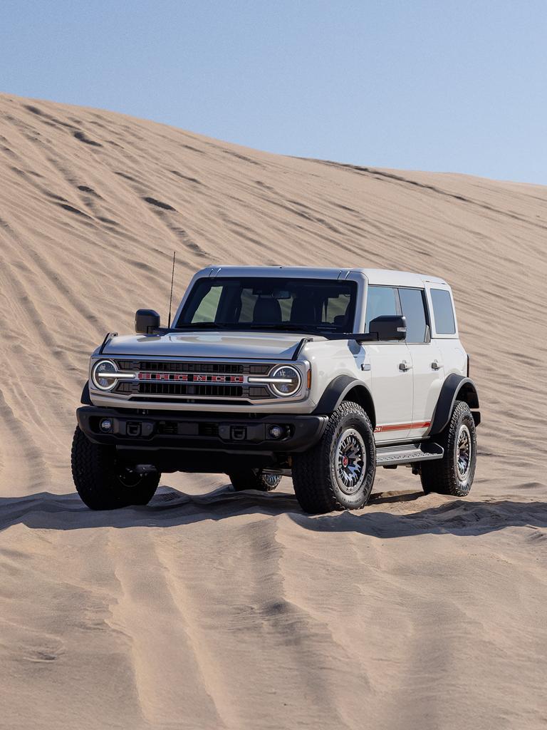 2026 Ford Bronco® SUV with the available 60th Anniversary Package parked on a sand dune on a sunny morning