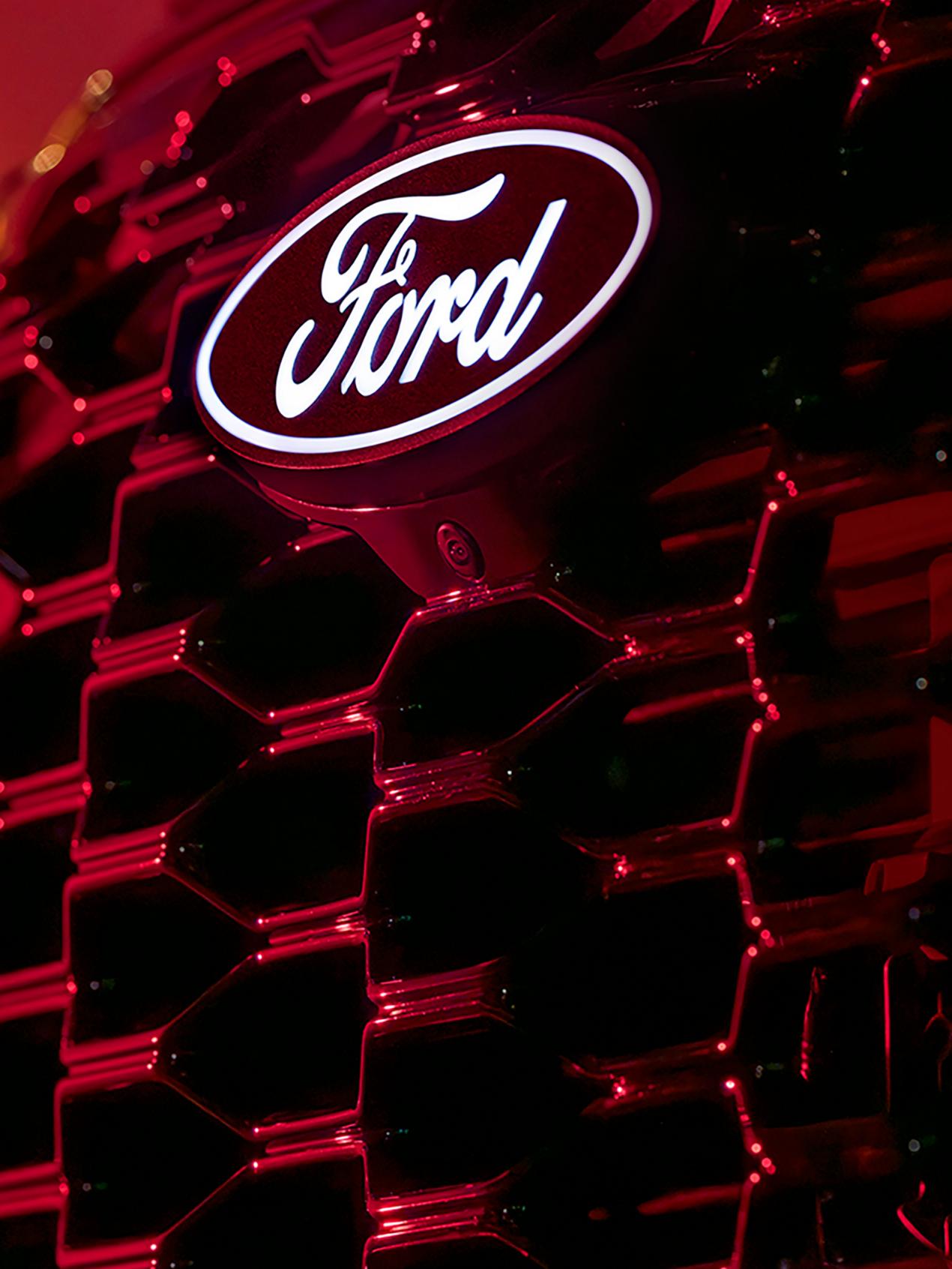 A close-up of the available illuminated hood badge and camera on a 2027 Ford Explorer® ST-Line model