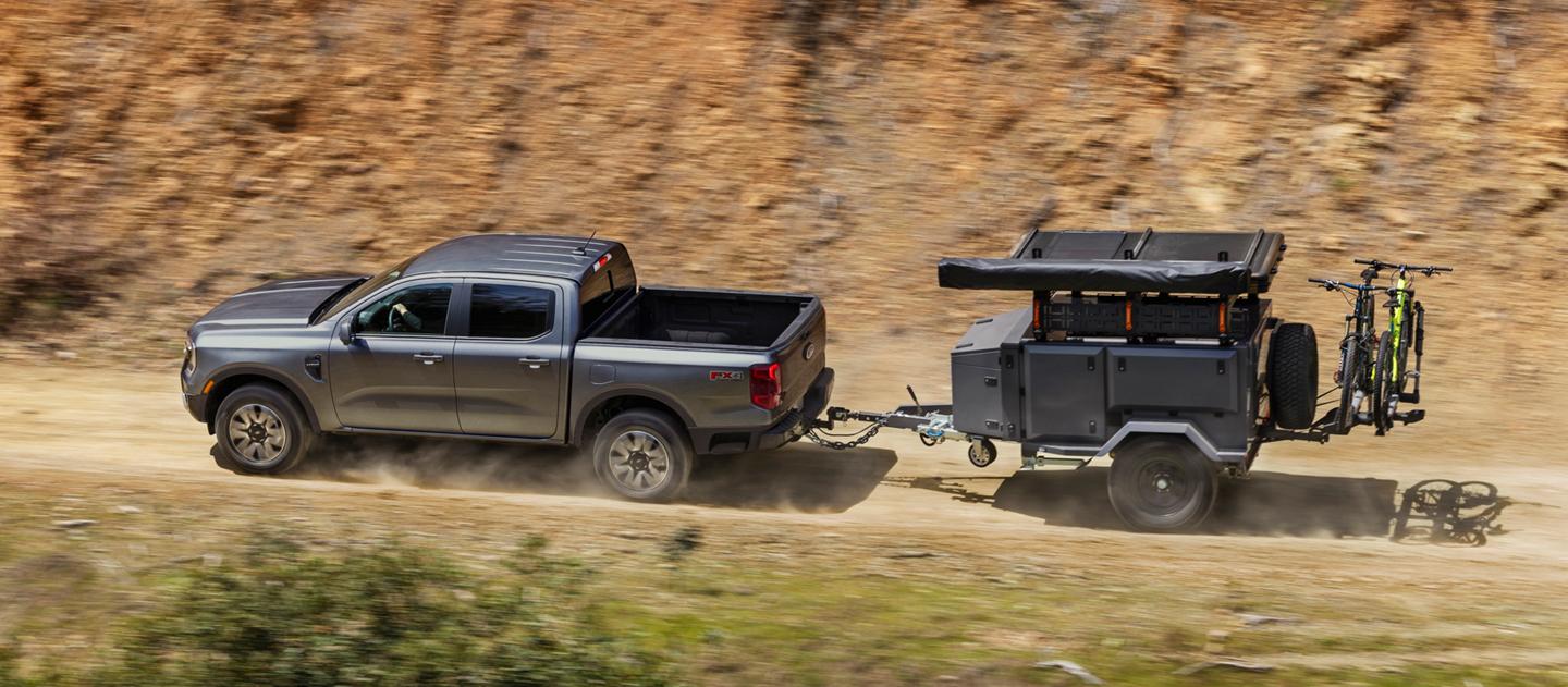2026 Ford Ranger® Lariat® truck towing a trailer on a dirt mountain road