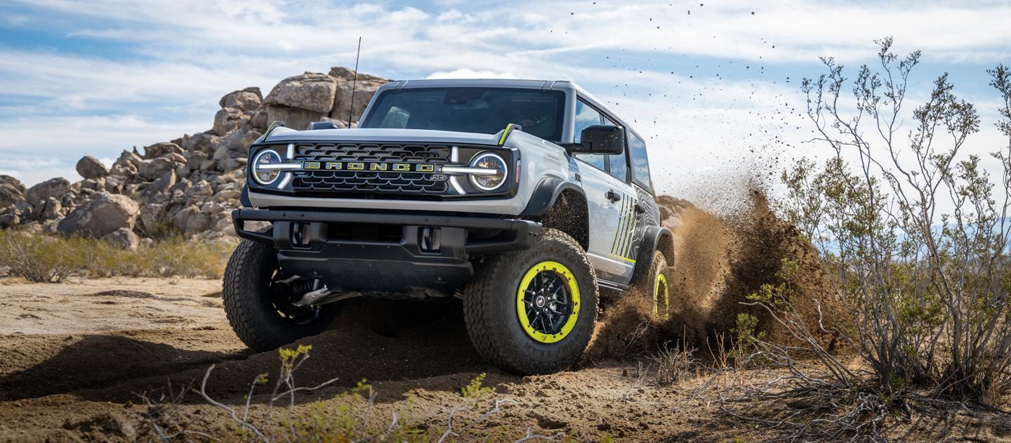 A 2027 Ford Bronco® RTR model being driven on a scrubby desert landscape
