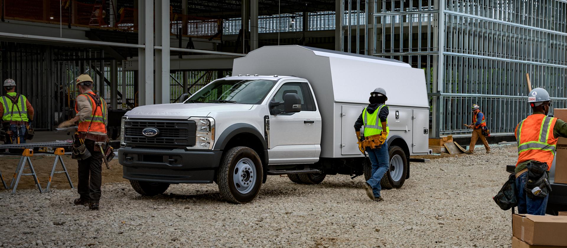 Workers using a 2026 Ford Super Duty® Chassis Cab with a utility box at construction site