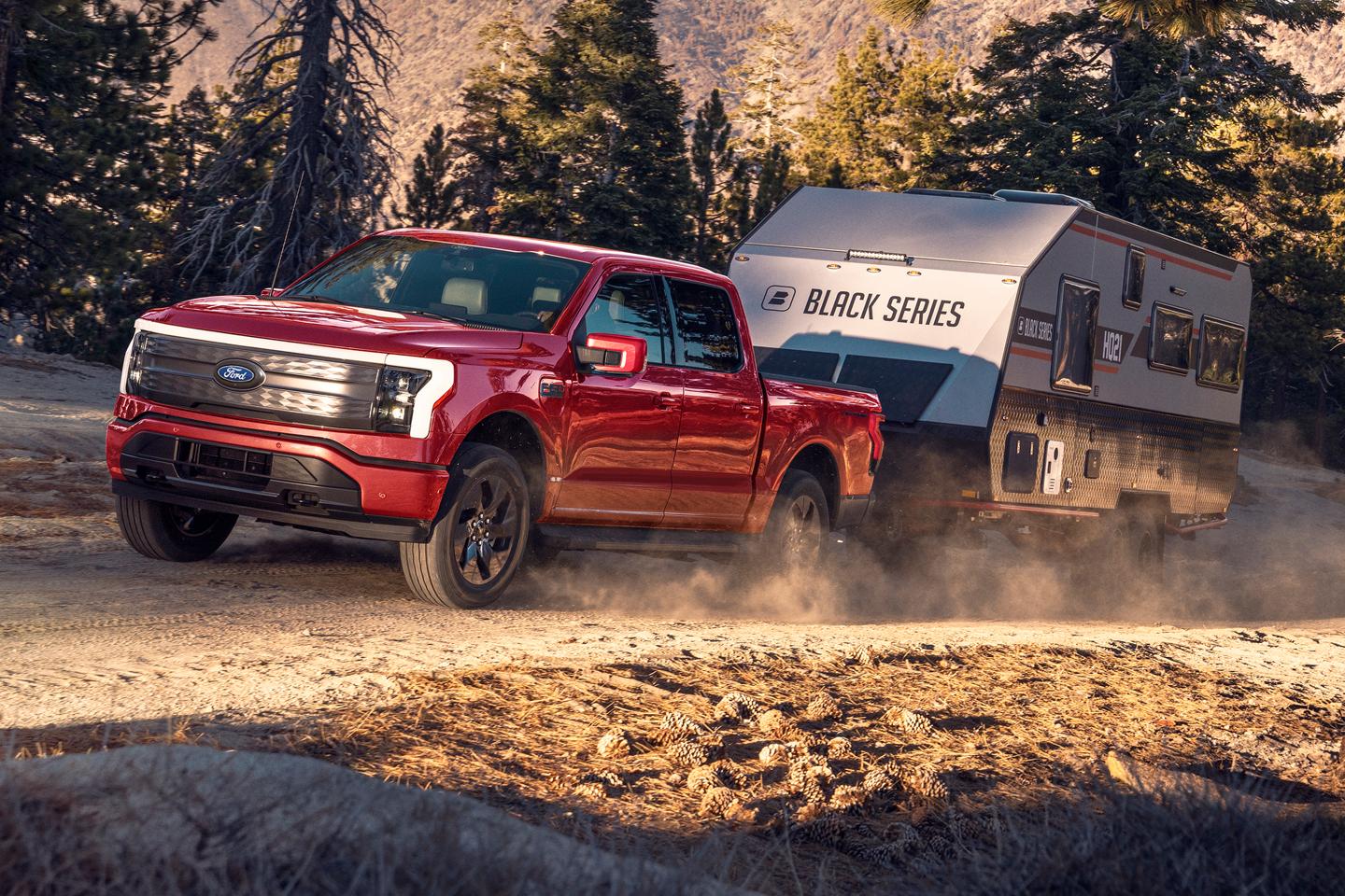 F-150 Lightning driving on a mountain road while towing a trailer.