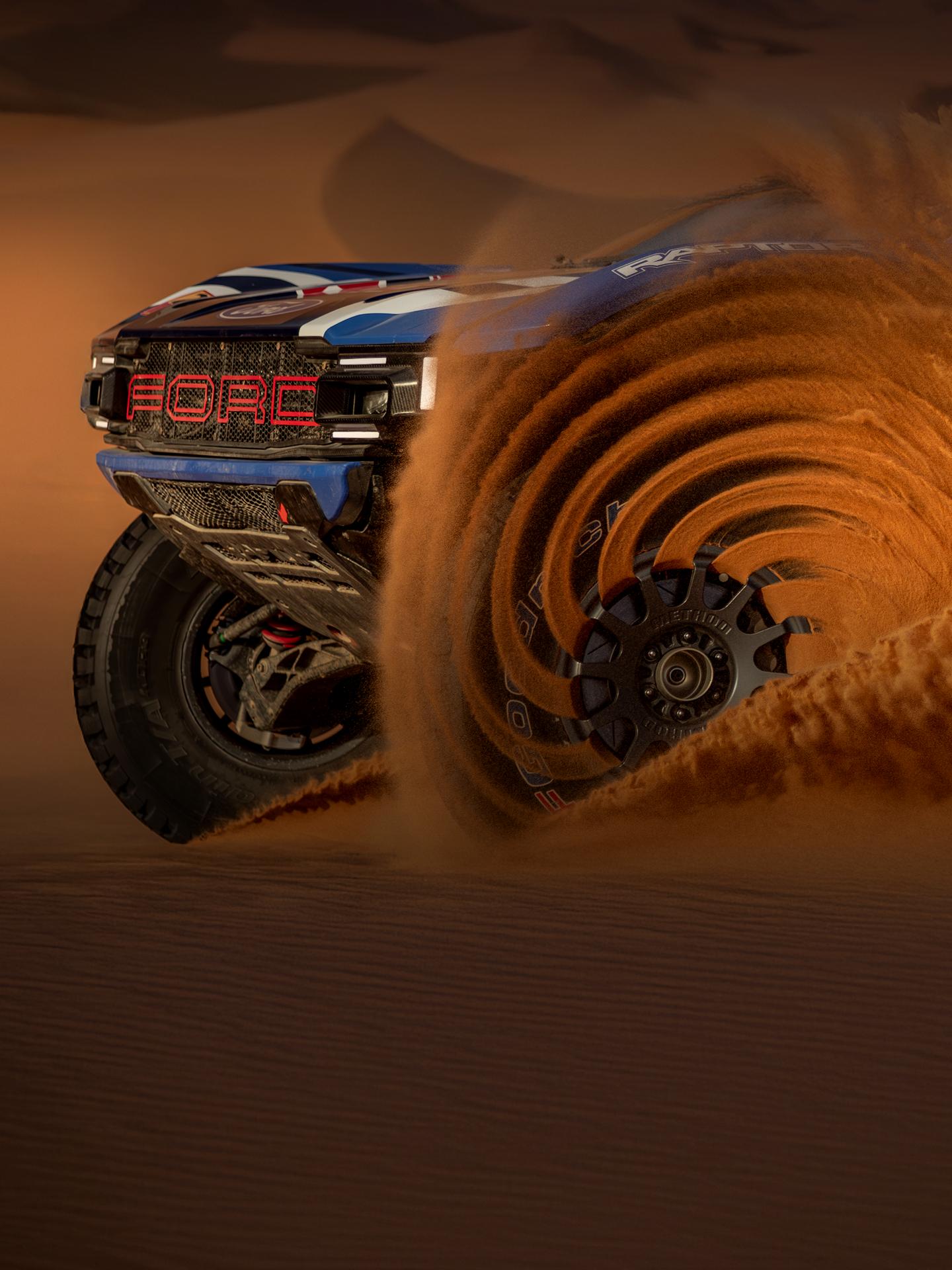 Ford vehicle driving through sand.