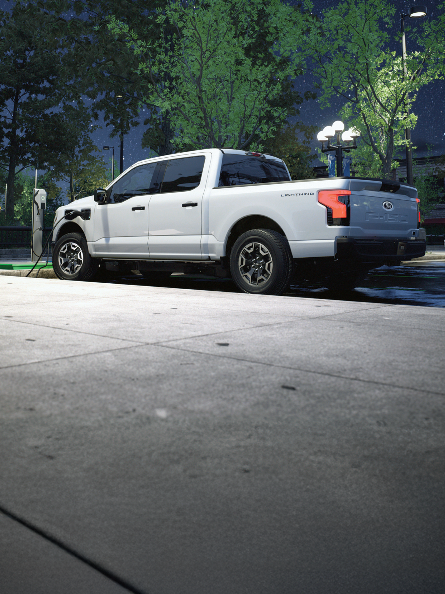 A Ford F-150 Lightning plugged into a public charging station.