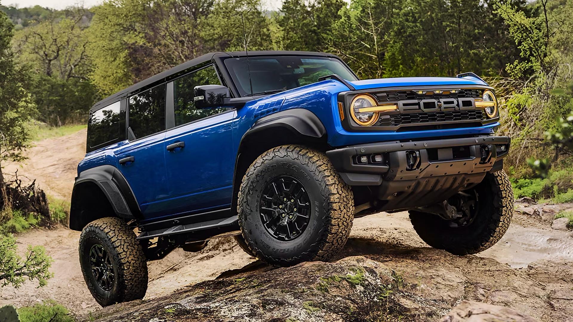A 2025 Ford Bronco® Raptor® SUV climbing a muddy hill in the forest