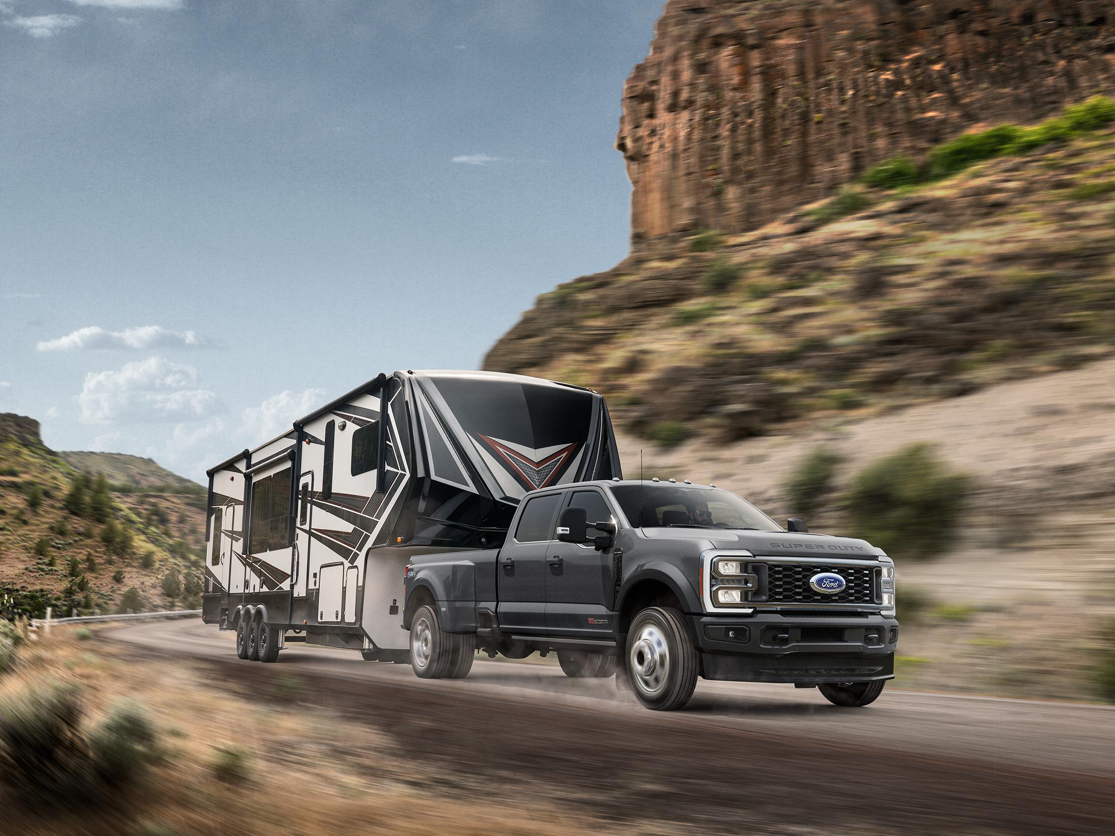 2026 Ford Super Duty® truck pulling a large camper on a mountain road