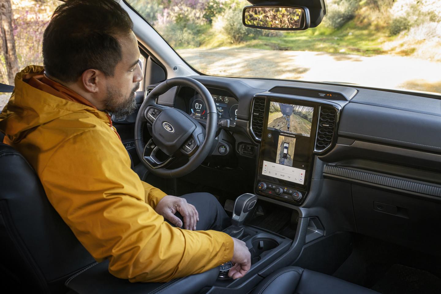 A person sitting in the driver's seat of their 2026 Ford Ranger® Lariat® truck and using the Pro Trailer Backup Assist™ feature