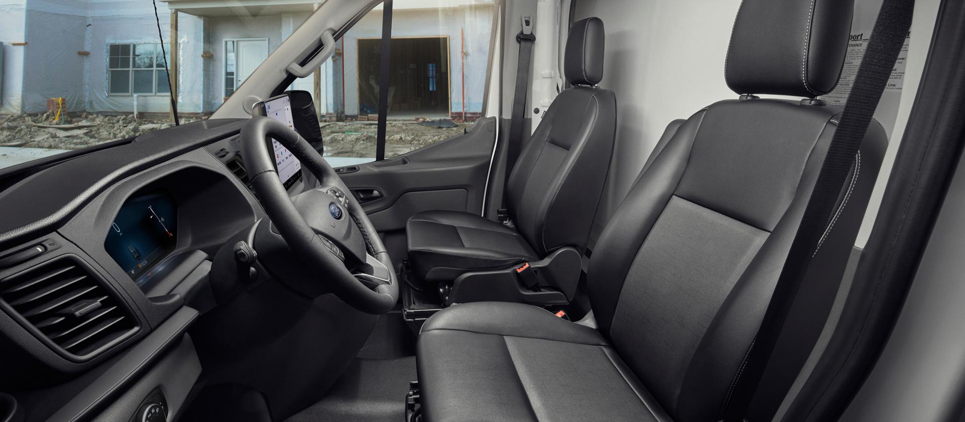 Interior cabin view of a 2027 Ford Transit® Cargo Van with black leather seats showing a construction site