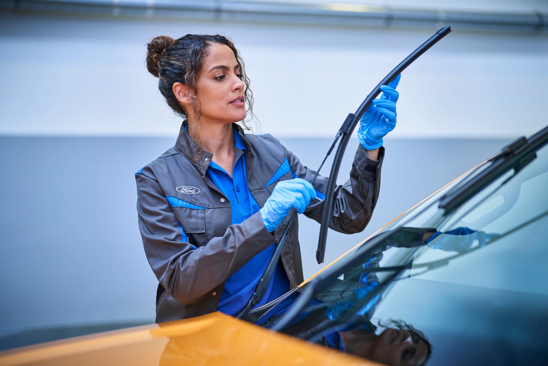A Ford Service employee works on a vehicle.