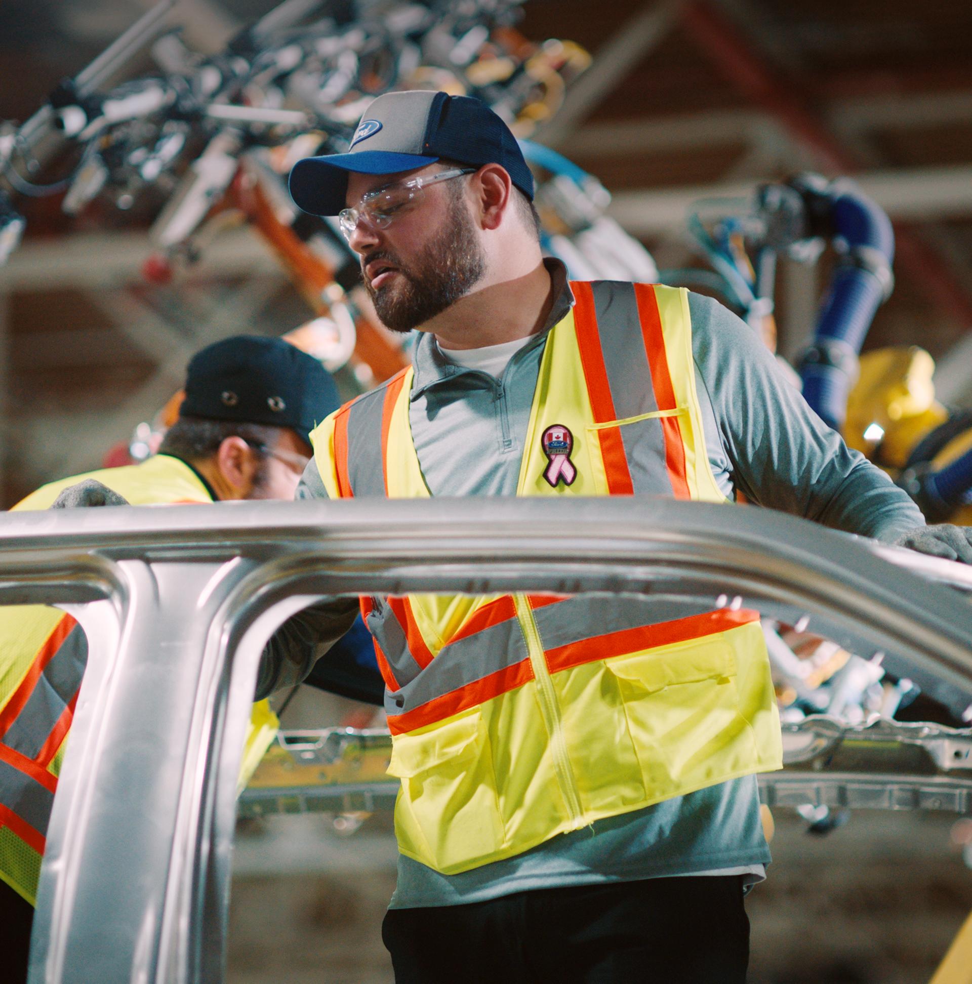 A Ford employee assembles a vehicle. 