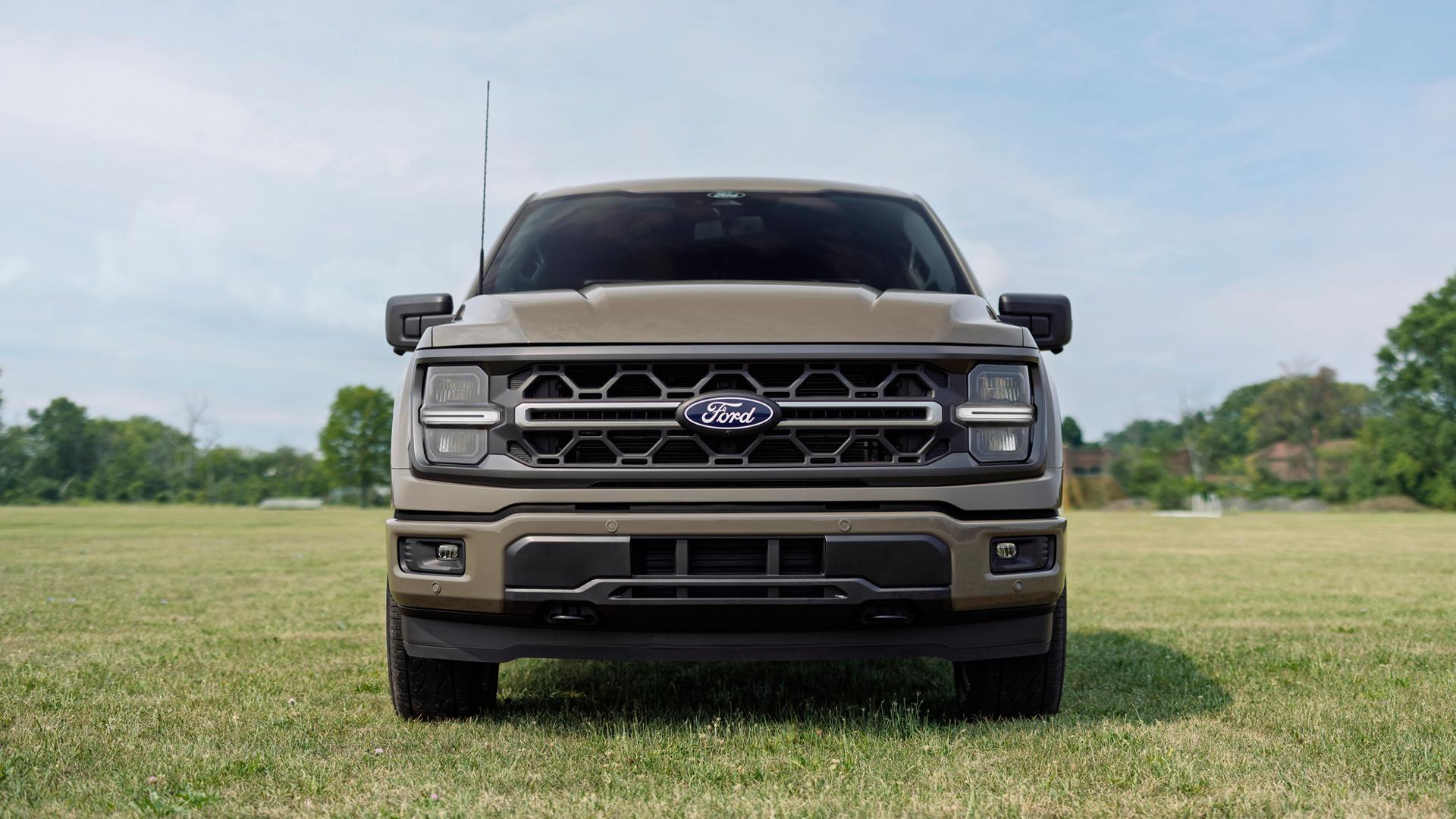 Front view of the grille on a 2027 Ford F-150® XLT model with the Carhartt® Package parked in a field