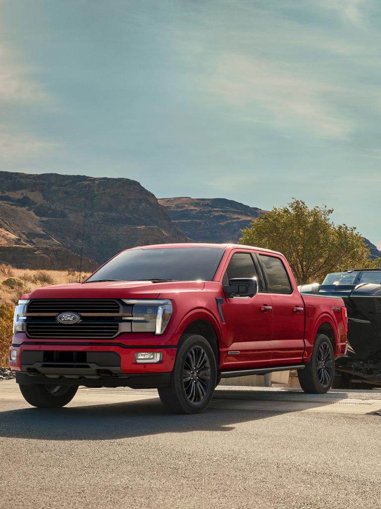 2025 Ford F-150® STX® FX4 pickup in Ruby Red Metallic pulling a boat out of the water