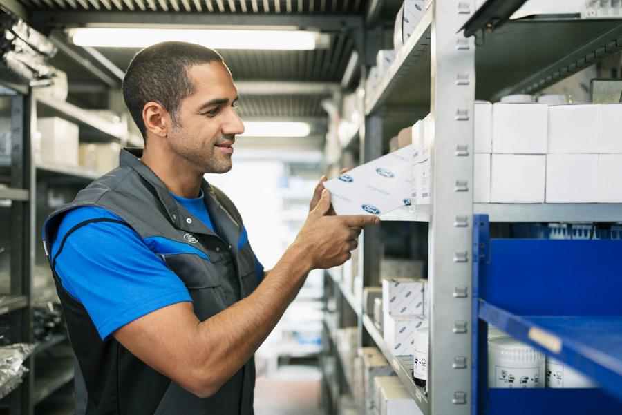 A Ford technician searches for parts on a shelf