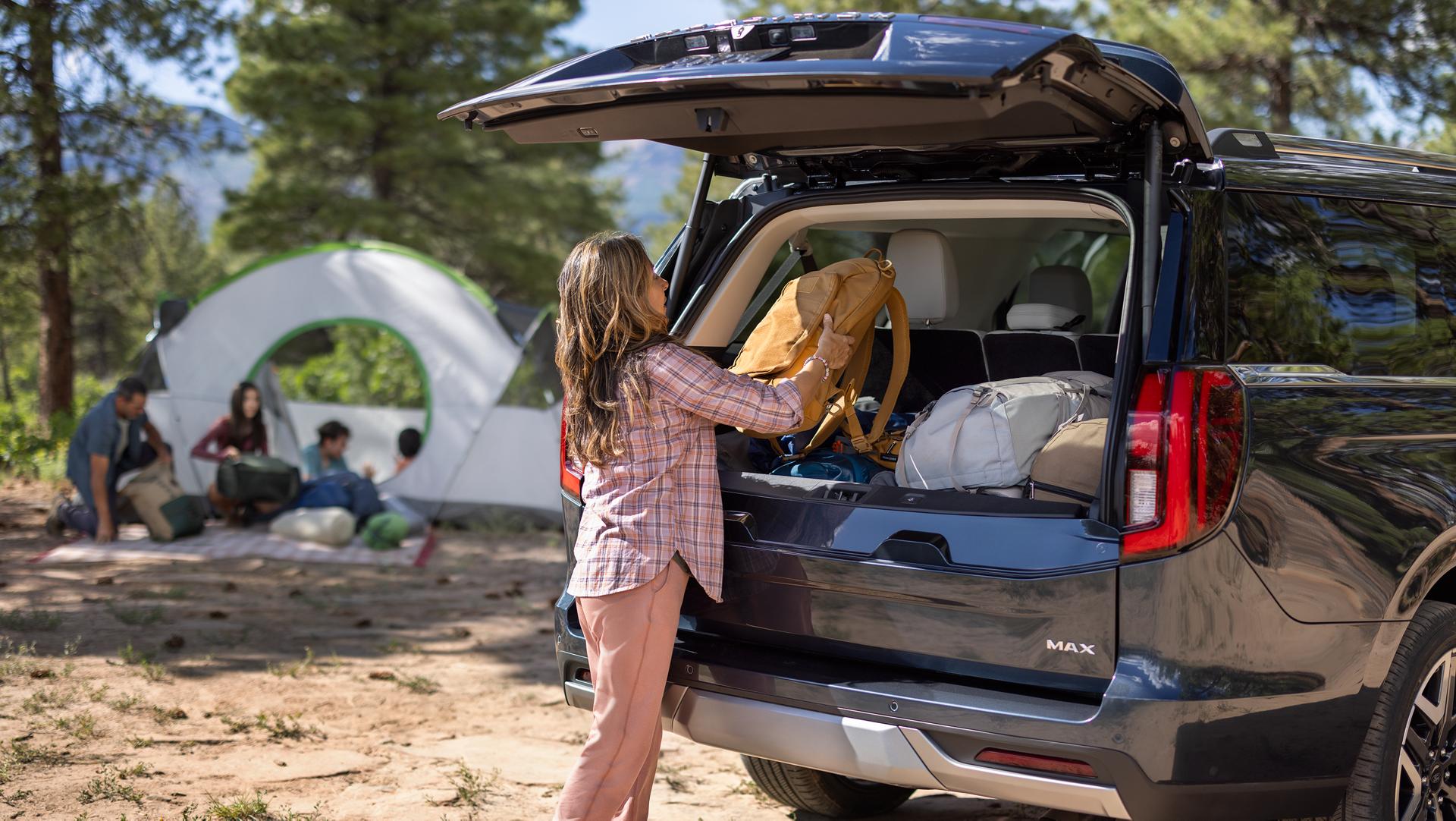 Person loading camping gear with the Ford Split Gate open in a 2026 Ford Expedition® SUV