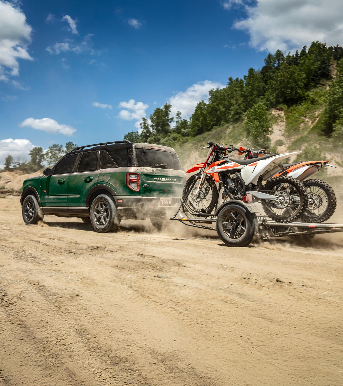 Ford Bronco Sport with attached trailer loaded with dirt bikes.