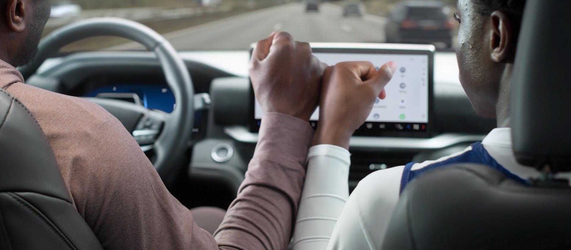 A driver and passenger touching hands in a 2026 Ford Explorer® SUV while BlueCruise is active