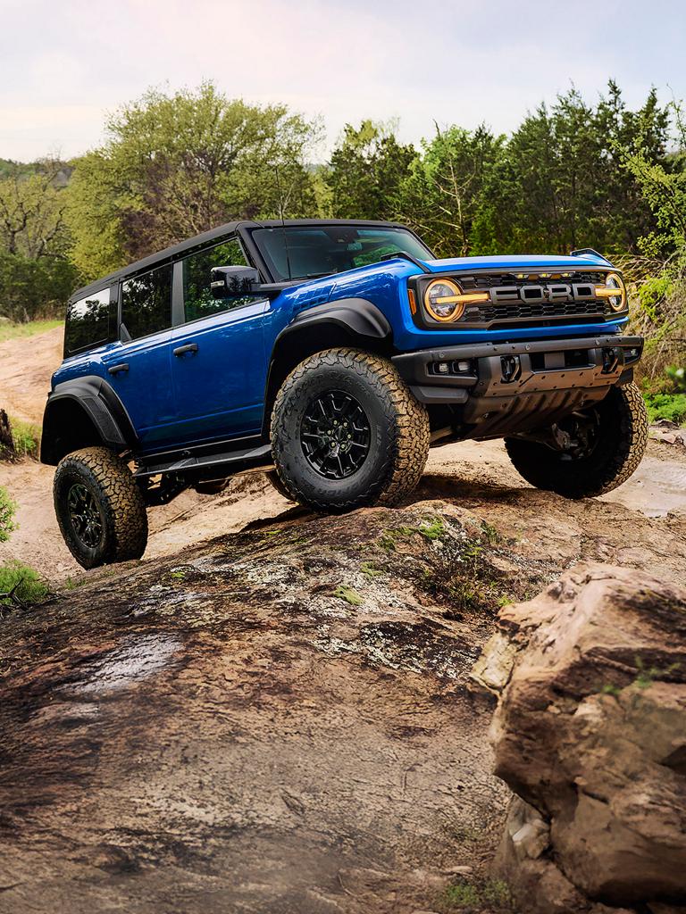 A 2026 Ford Bronco® Raptor® SUV with the available Black Appearance Package being driven over a rock formation