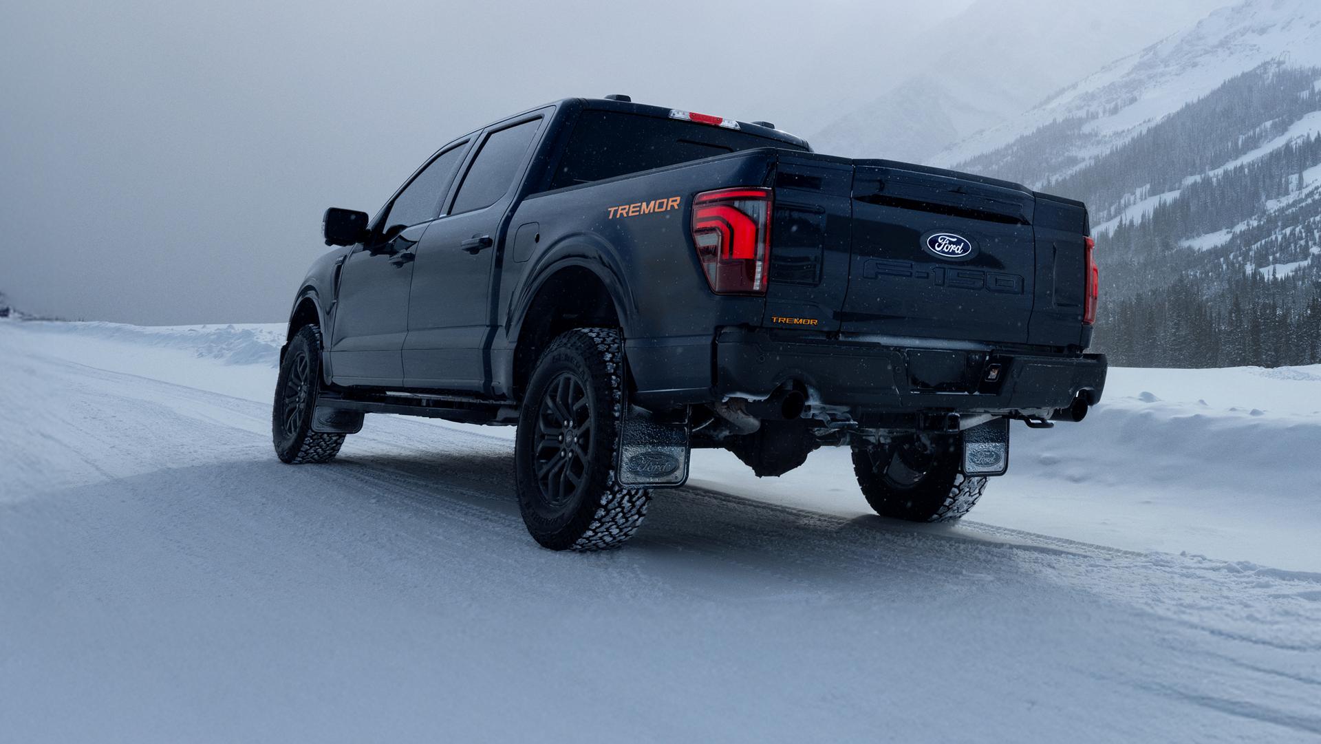 Rear view of an F-150 Tremor driving on a snow-covered mountain road.