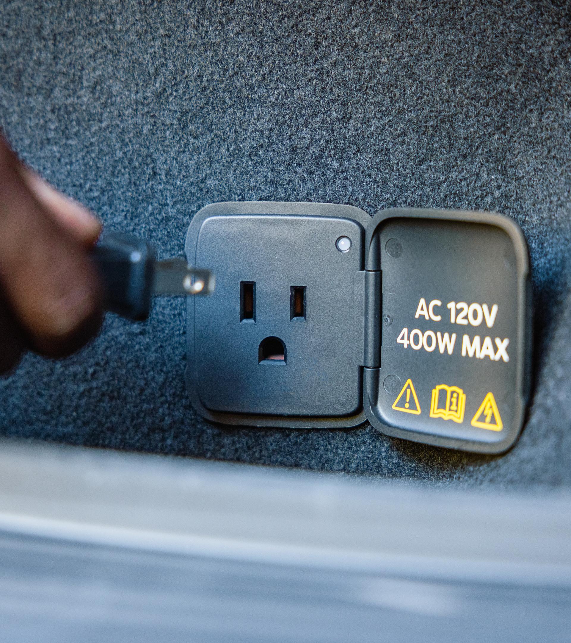 A 110V outlet in the cargo area of a 2027 Mustang Mach-E® SUV with optional Trail package