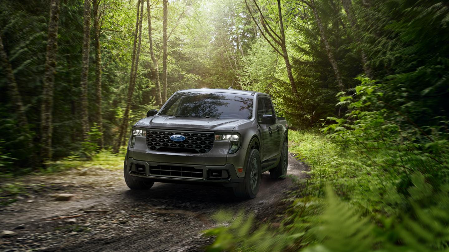 A 2026 Ford Maverick® XLT model with FX4® Off-Road Package being driven on a muddy forest trail