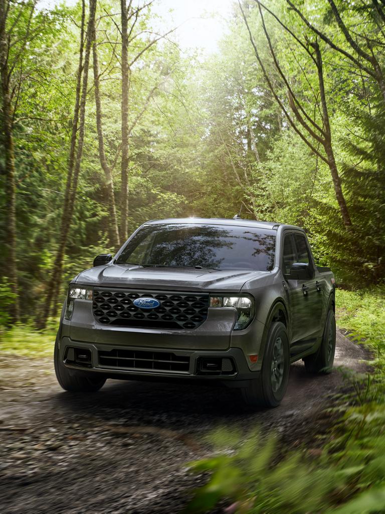 2026 Ford Maverick® pickup driving on a muddy trail through the woods