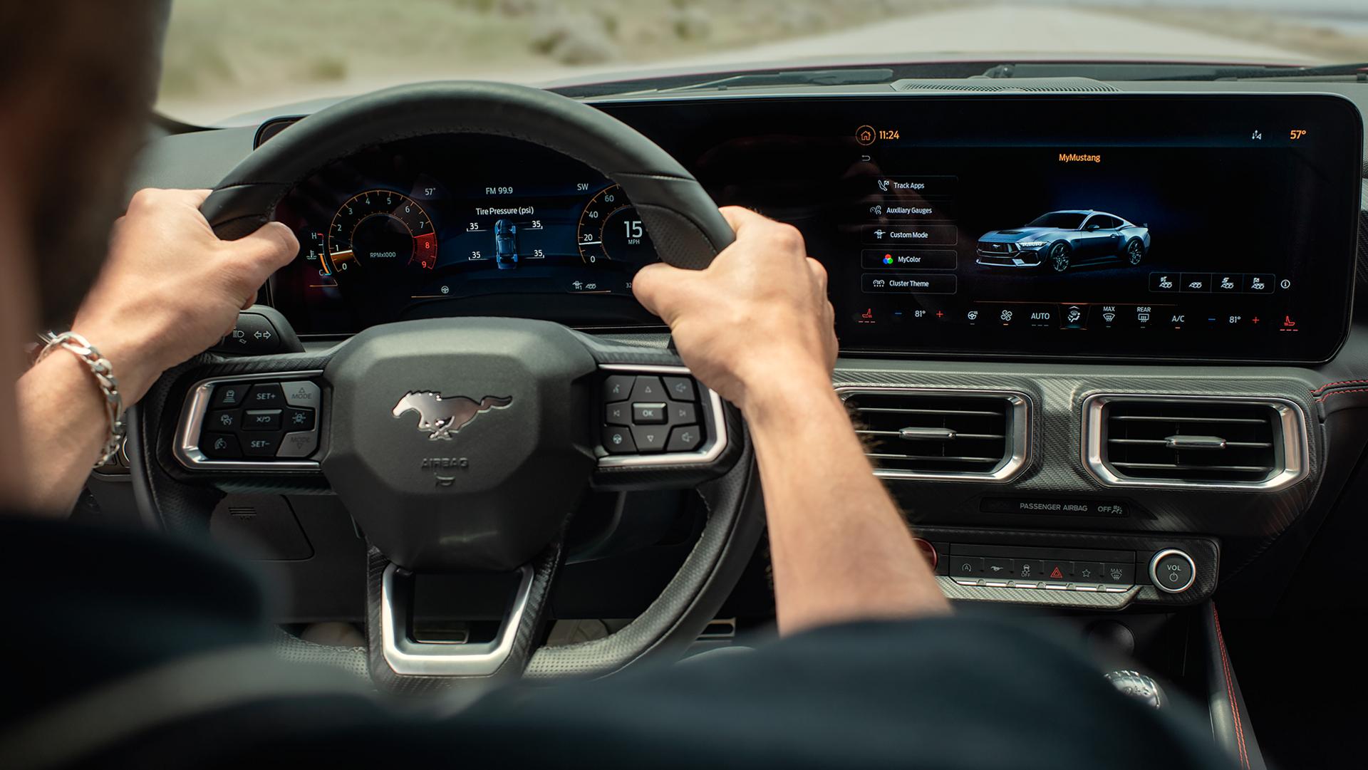 Person driving a 2026 Ford Mustang® model with the available 12.4-inch cluster display and 13.2-inch centre display