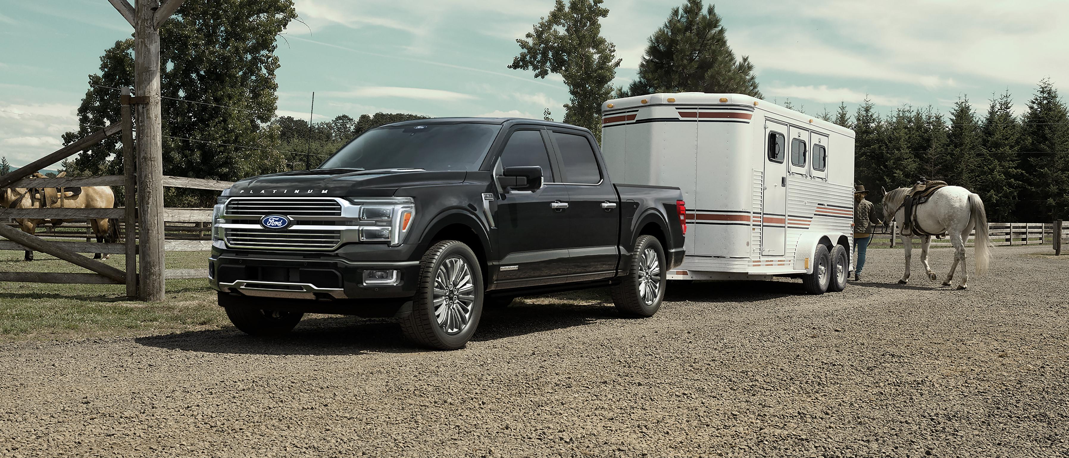 2025 Ford F-150® Platinum® Plus model hitched to a horse trailer with a horse and person at the back
