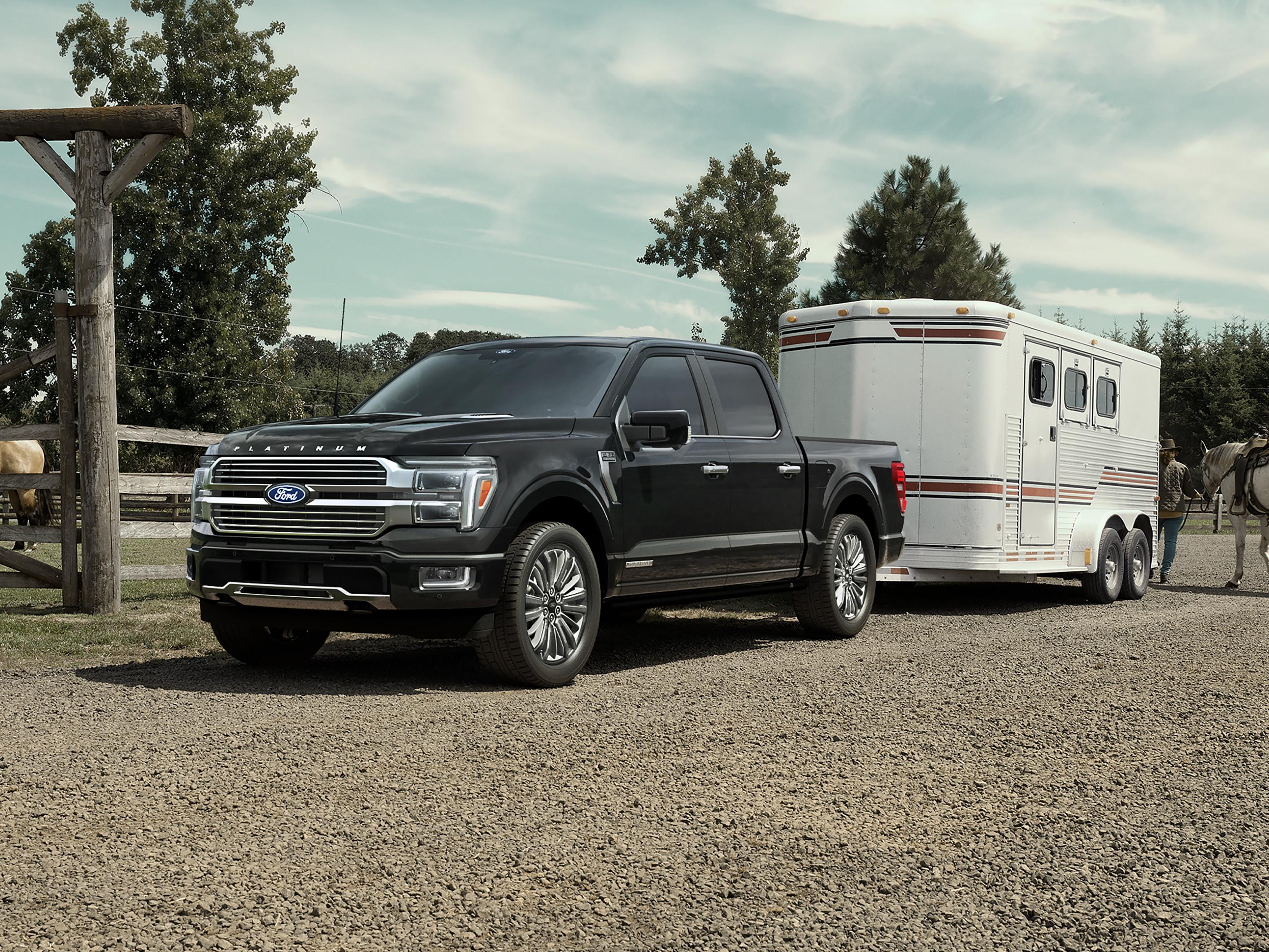 2025 Ford F-150® Platinum® in Agate Black parked with a trailer on a horse farm