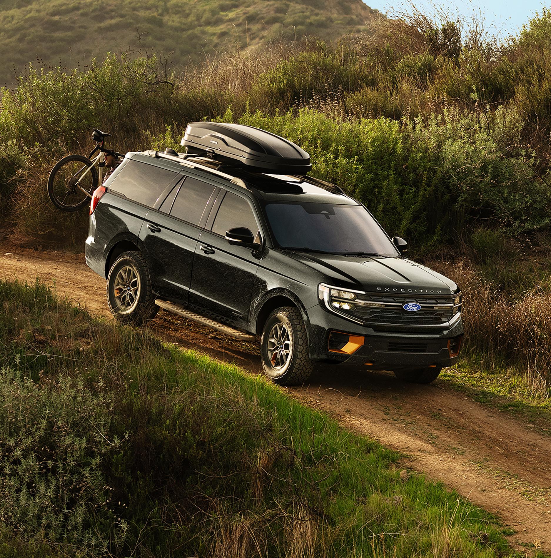 2027 Ford Expedition® Tremor® SUV with optional equipment and available Ford accessories shown being driven on a dirt road
