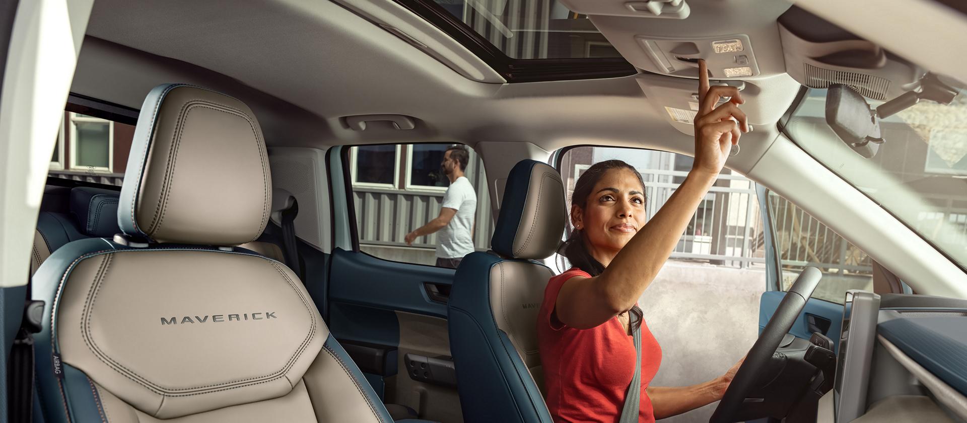 Interior view of the front passenger area showing the steering wheel, centre display, and centre stack controls