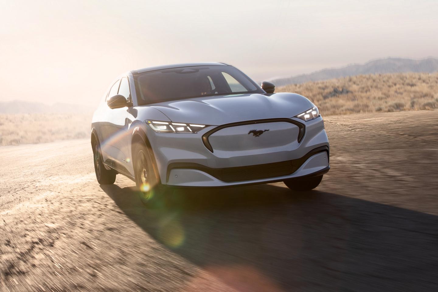 A white Mustang Mach-E® driving along a road.