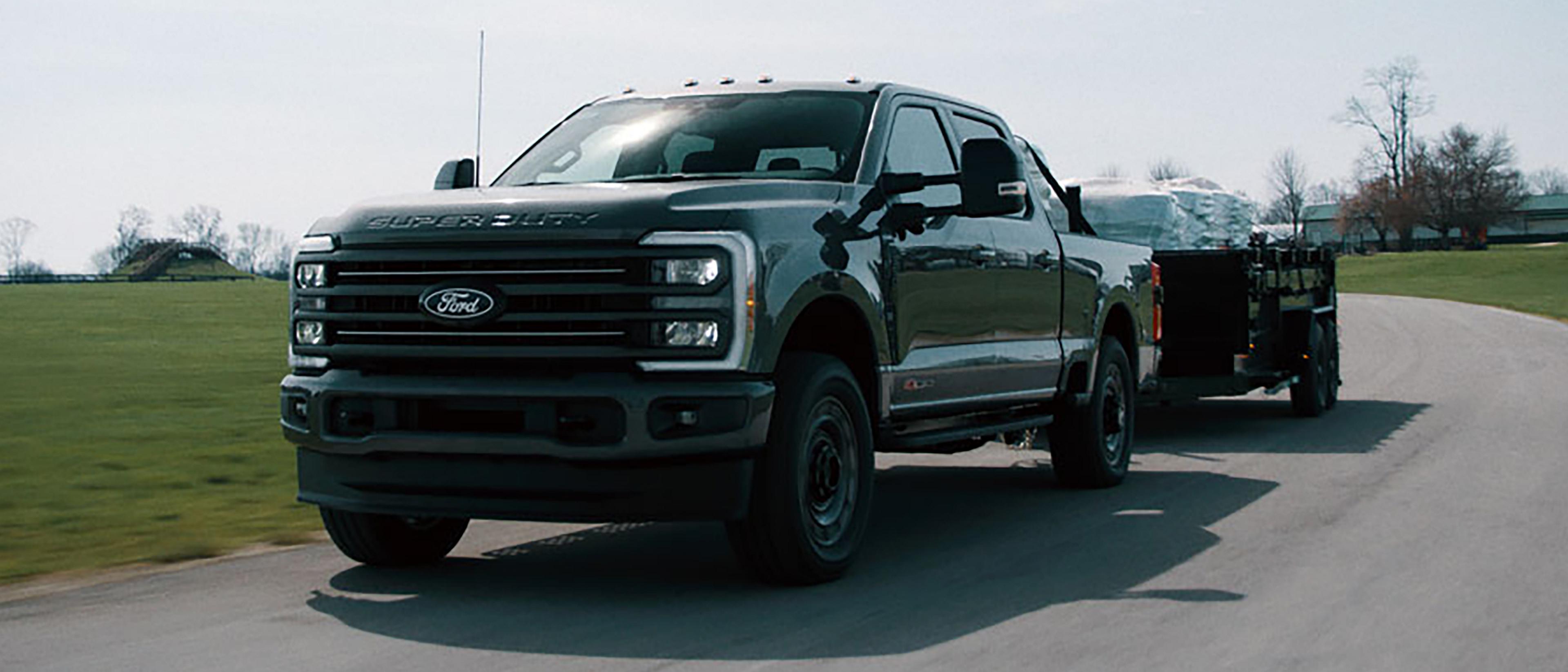 2027 Ford Super Duty® F-350® XLT model with the Super Duty Carhartt® Package towing a flatbed trailer