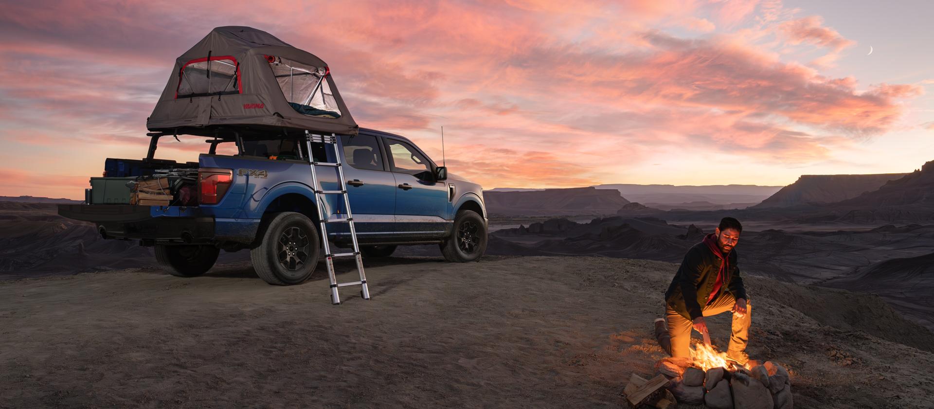 2025 Ford F-150® FX4® pickup in Atlas Blue with a Ford Accessories truck bed tent at dusk