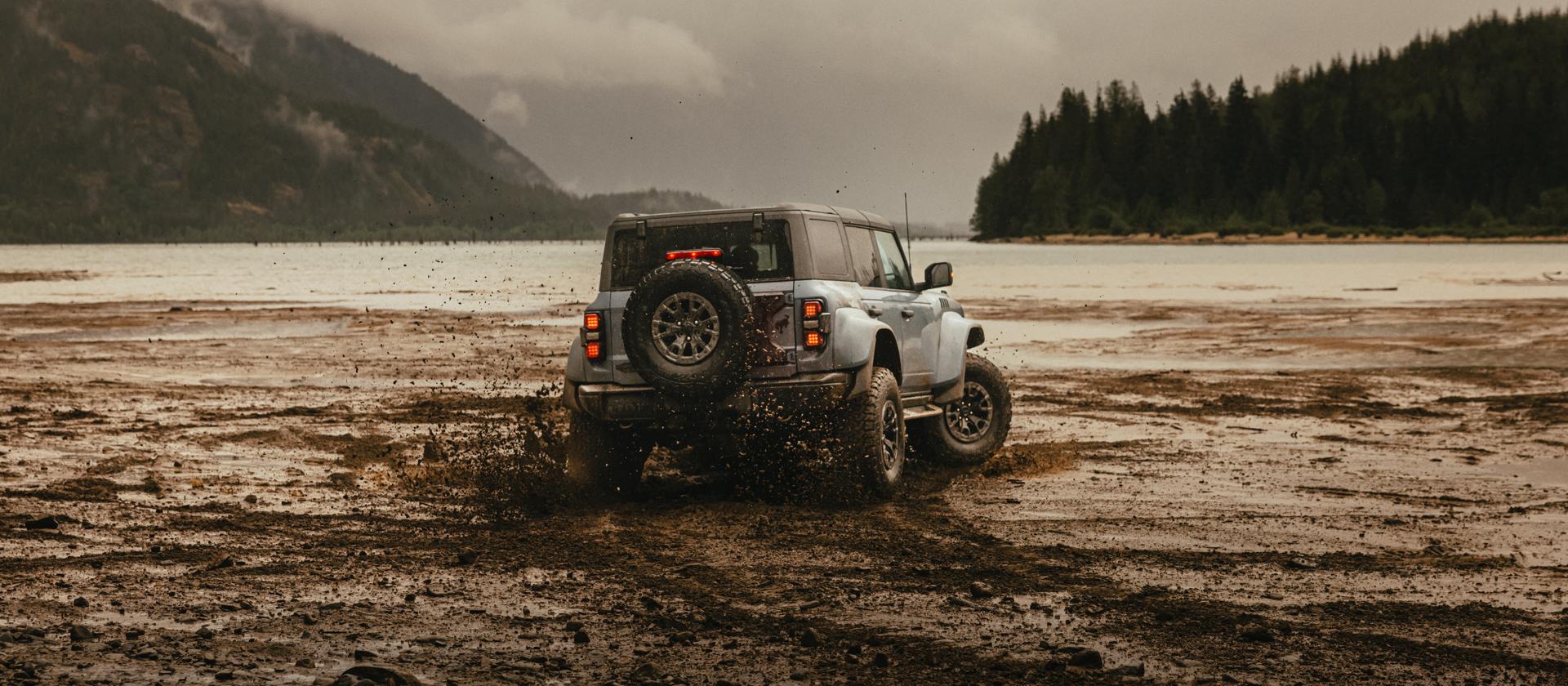 A 2025 Ford Bronco® SUV leaving tire tracks on a mud flat in a valley