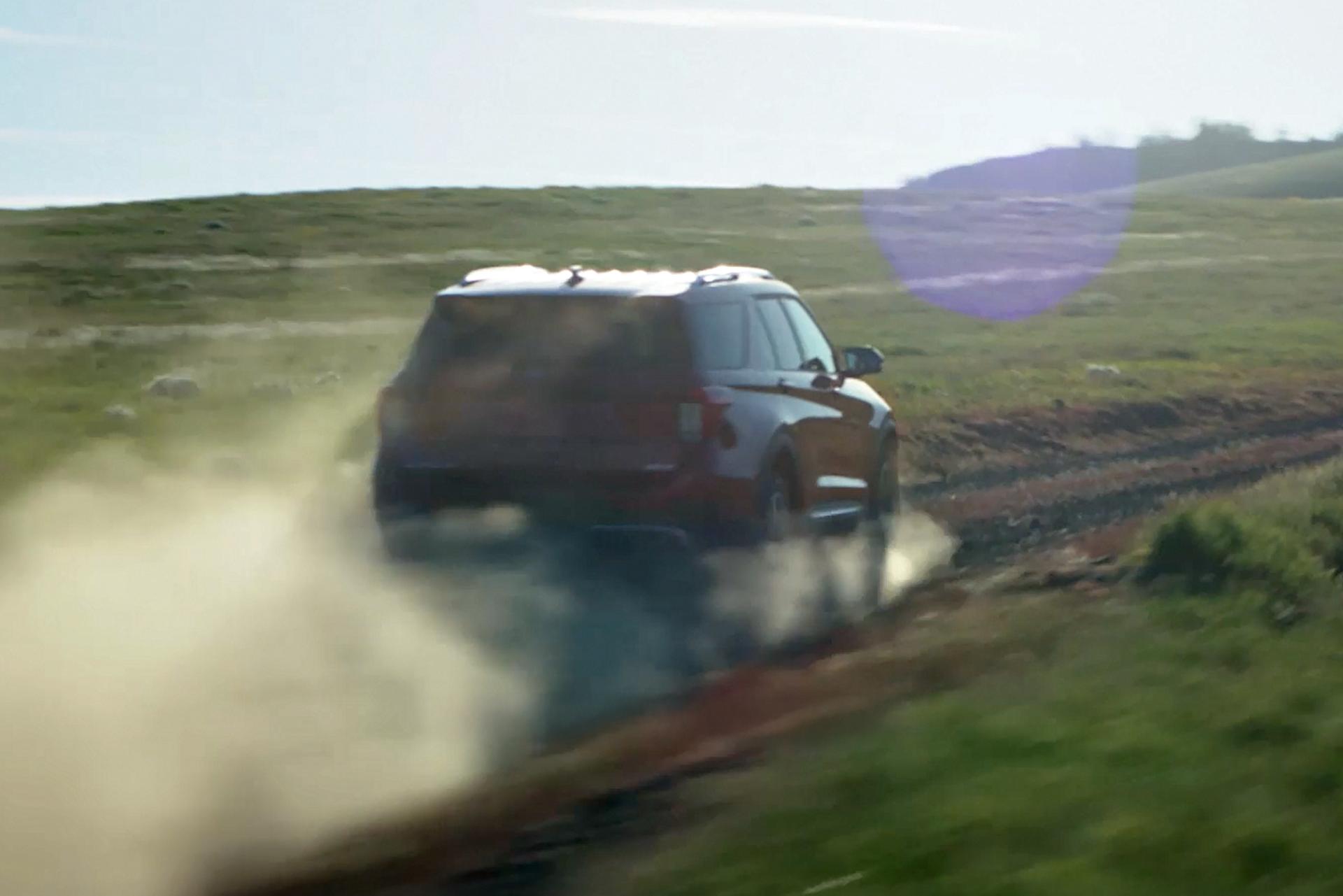A 2026 Ford Explorer® SUV kicking up dust while being driven down a dirt road