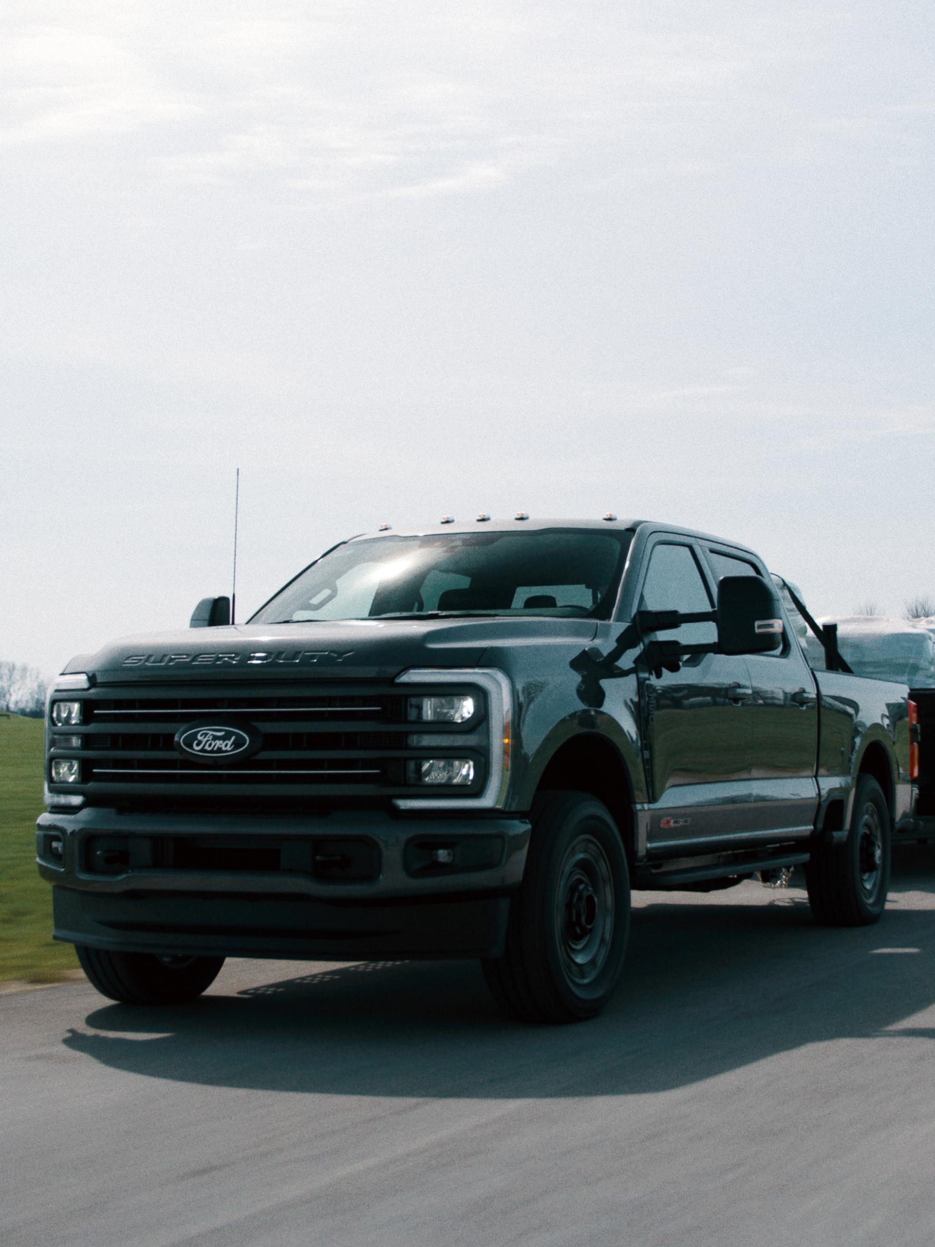 2027 Ford Super Duty® F-350® XLT model with the Super Duty Carhartt® Package towing a flatbed trailer